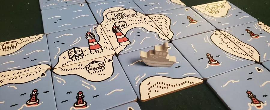 Beacon Patrol. A tile-based board game depicting an island with lighthouses, beaches, and a castle, with some 3D piece representations of a boat or ship placed on the tiles.