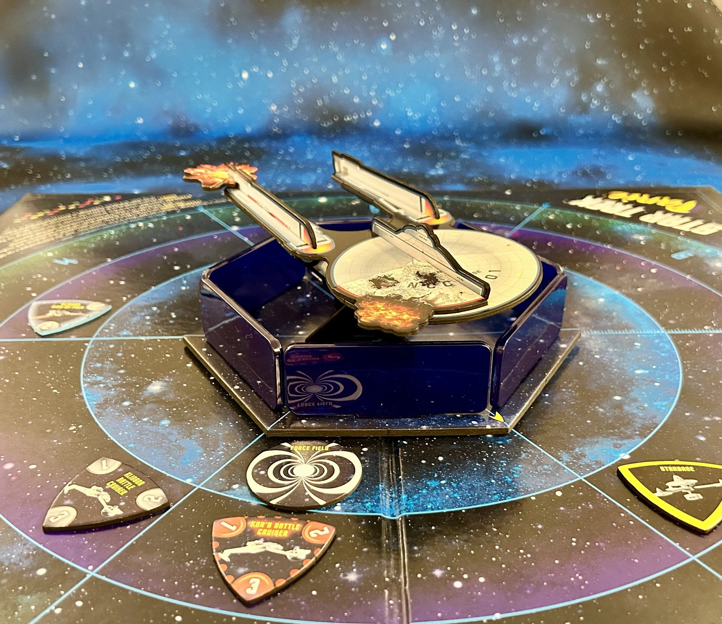 A space-themed board game with a rotating radar hub in the center, surrounded by a starry game board and various game tokens depicting space ships and missions.