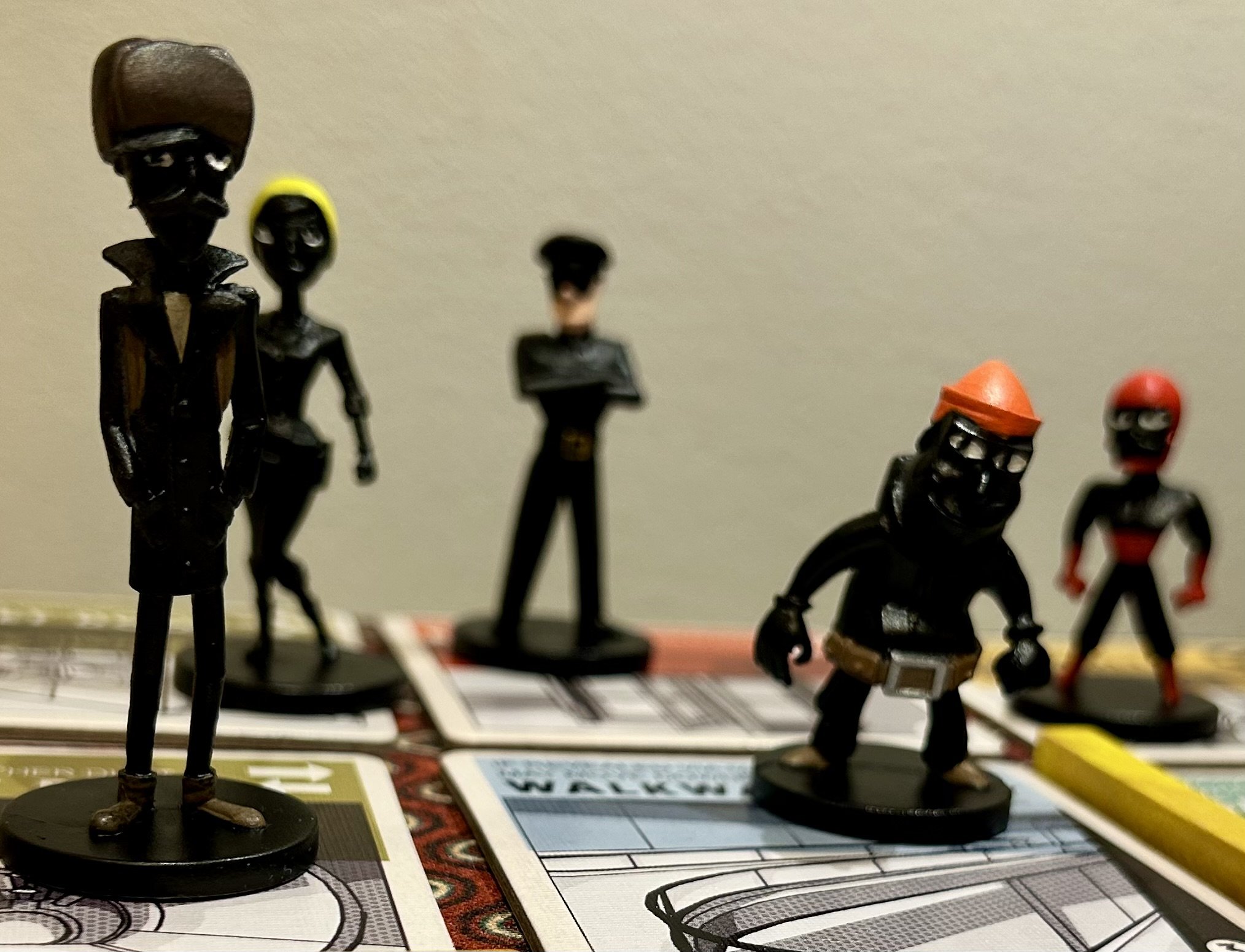 Board game pieces resembling pirates, with black and red attire, are placed on game boards.