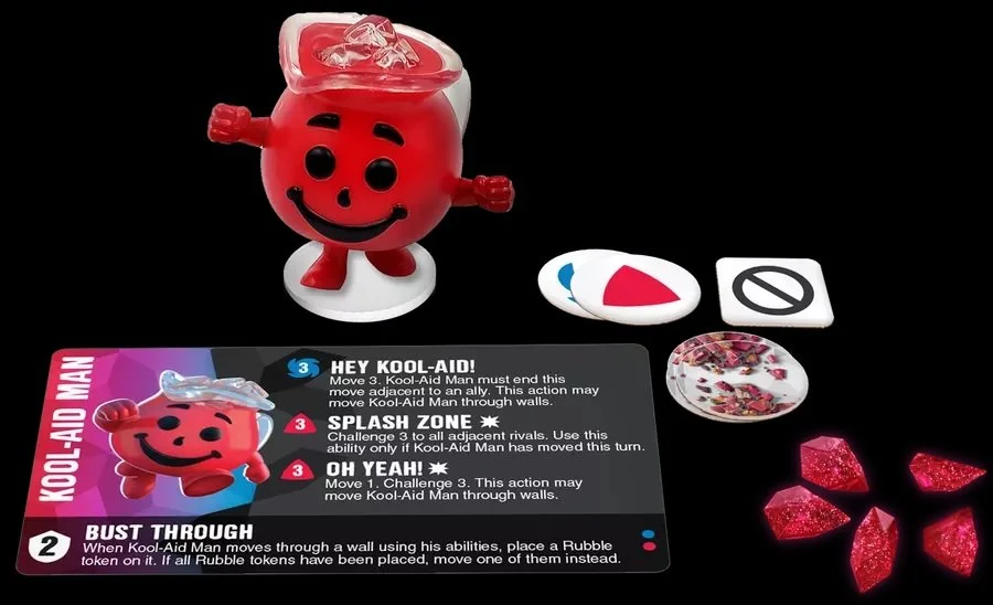 A game piece of Kool-Aid Man with a red body and a transparent head, resembling a Kool-Aid drink, is shown along with game cards, tokens, and red crystals. The card explains moves for the Kool-Aid Man character in the game.
