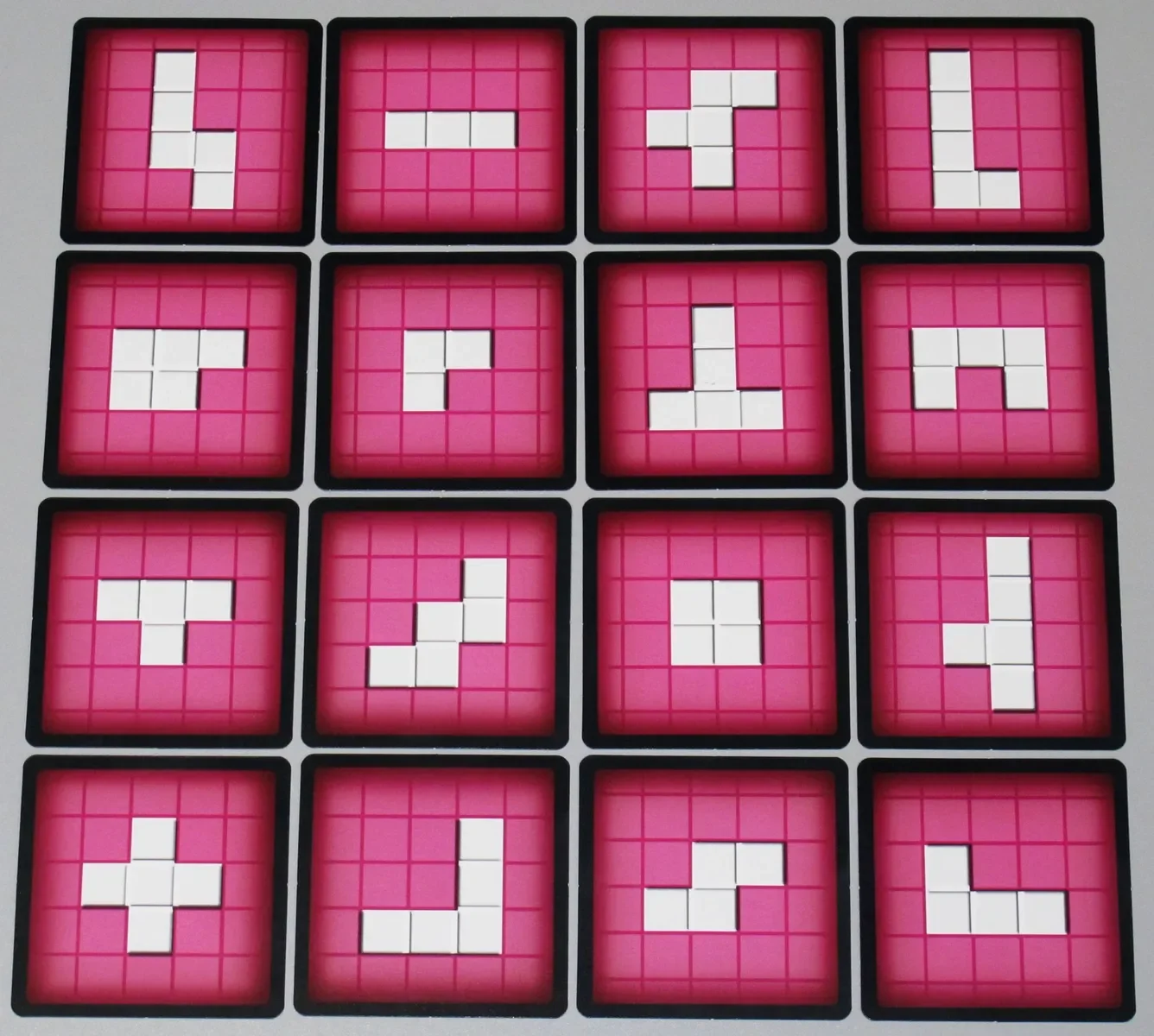 Bingo tetris grid of 15 pink squares with white tiles arranged to form various shapes.