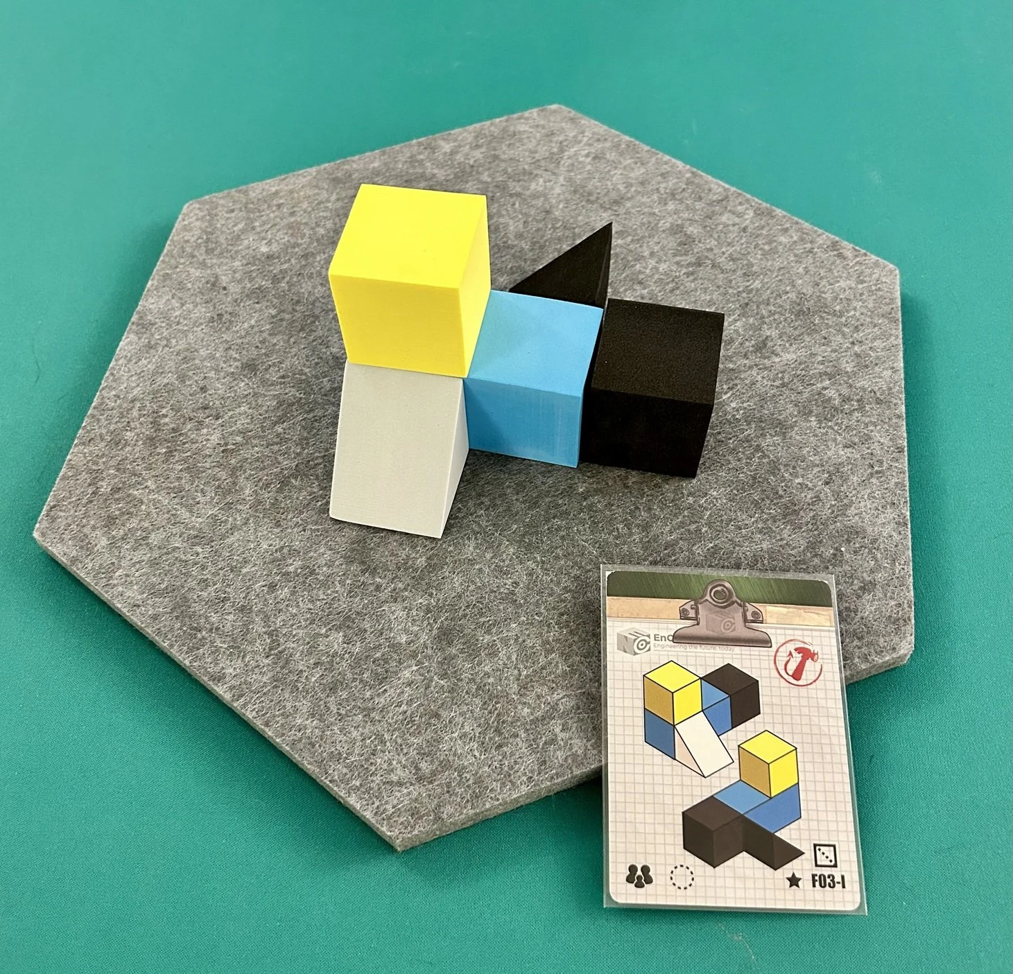 Colorful puzzle cubes assembled on a gray platform with an instruction card nearby.