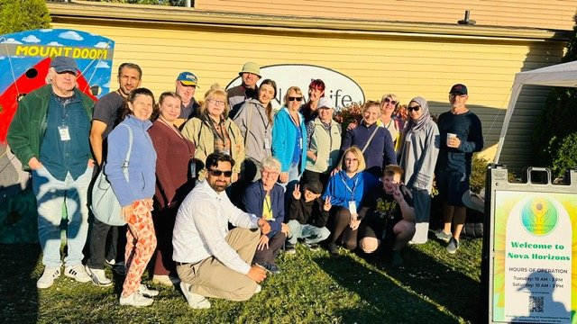 Large group of volunteers smile for the camera at an outdoor Nova Horizons event.