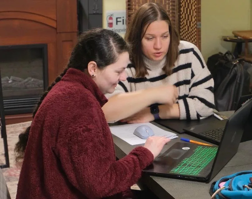 Ladies work at a computer at Nova Horizons.