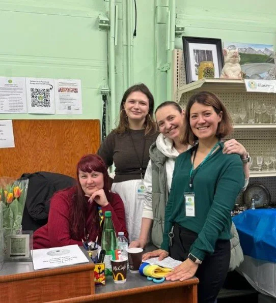 Four women smile from the front entrance welcome desk of Nova Horizons.