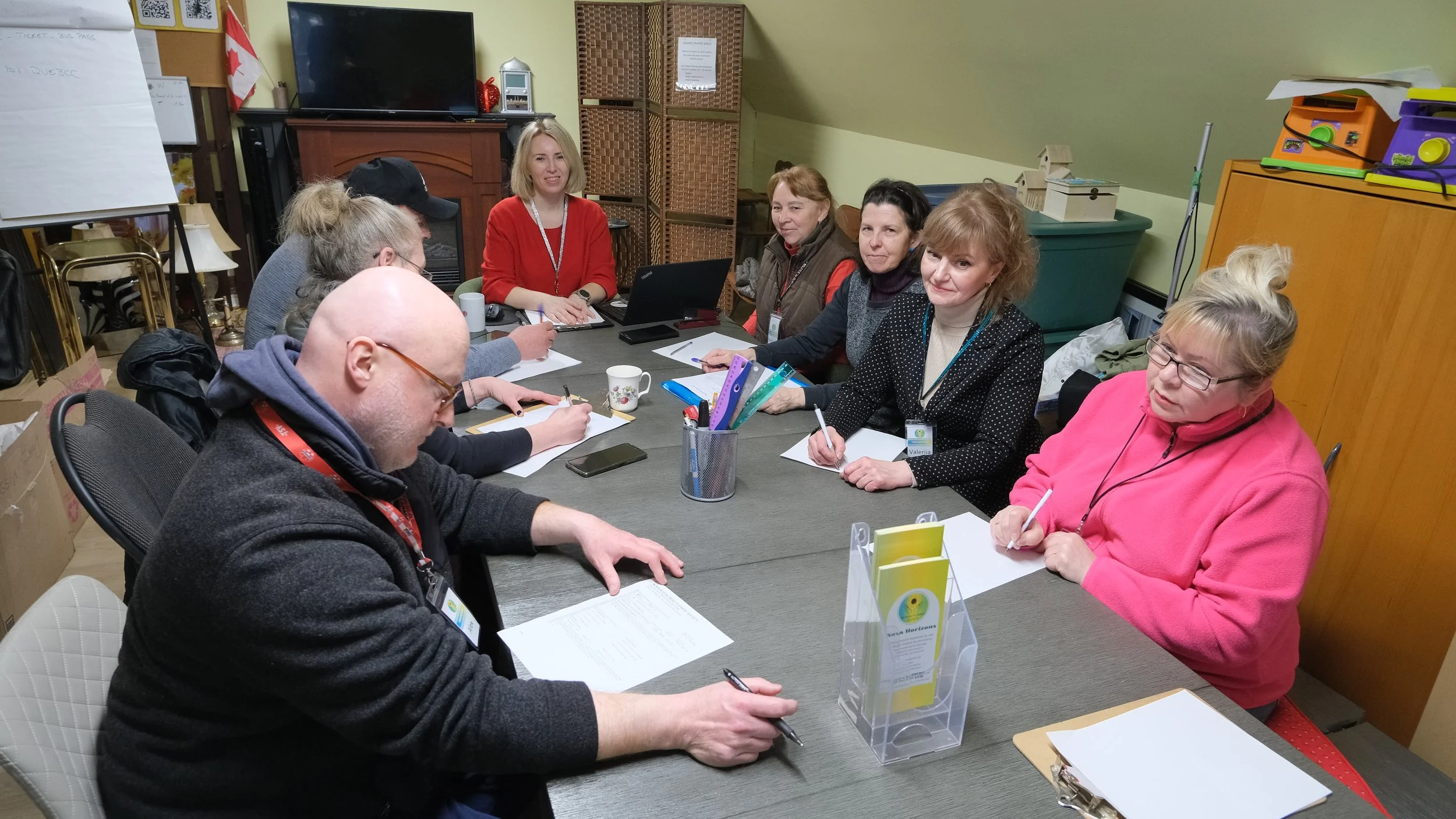 Volunteers host a meeting around a large table.