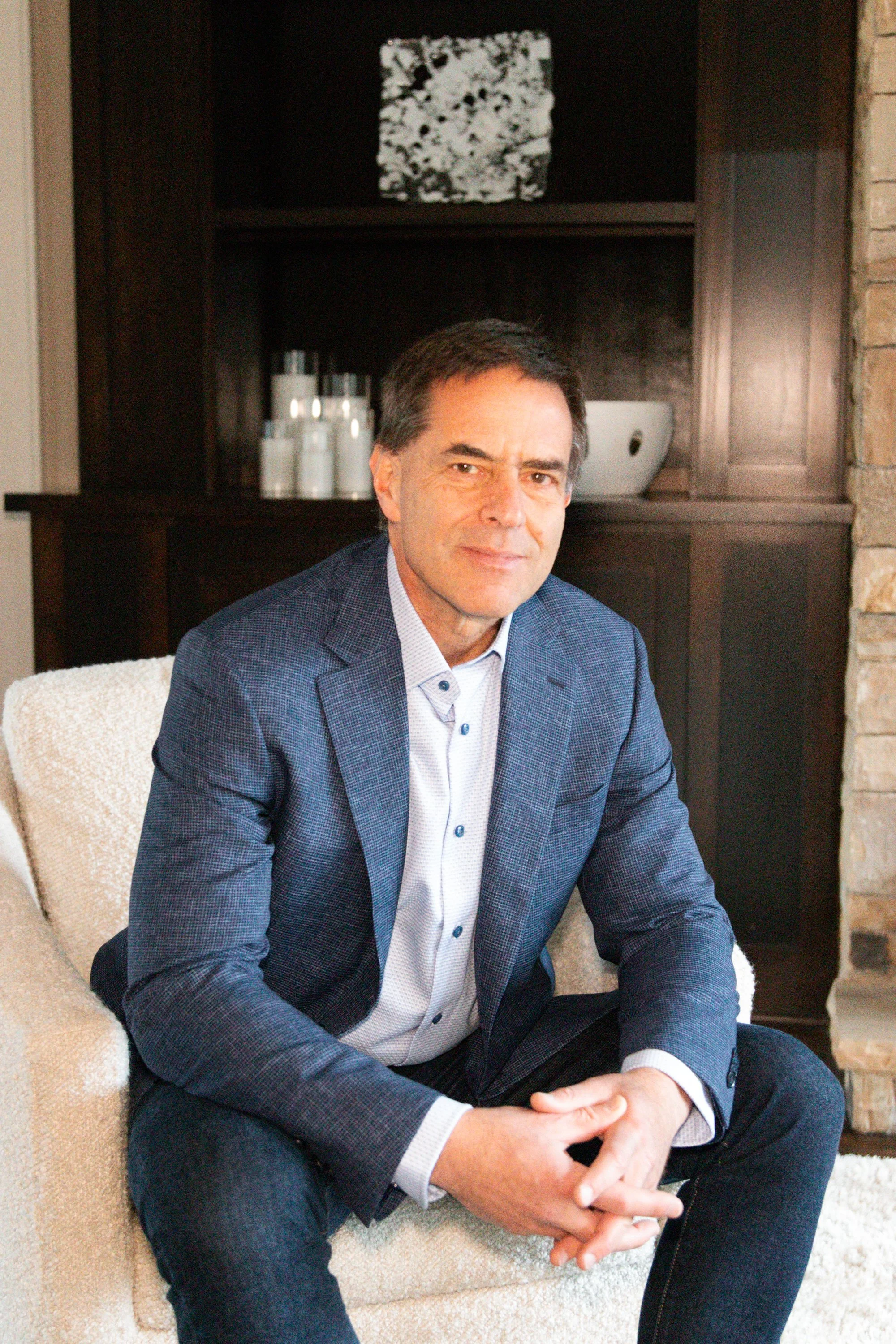 Kevin Abel in blue suit sitting