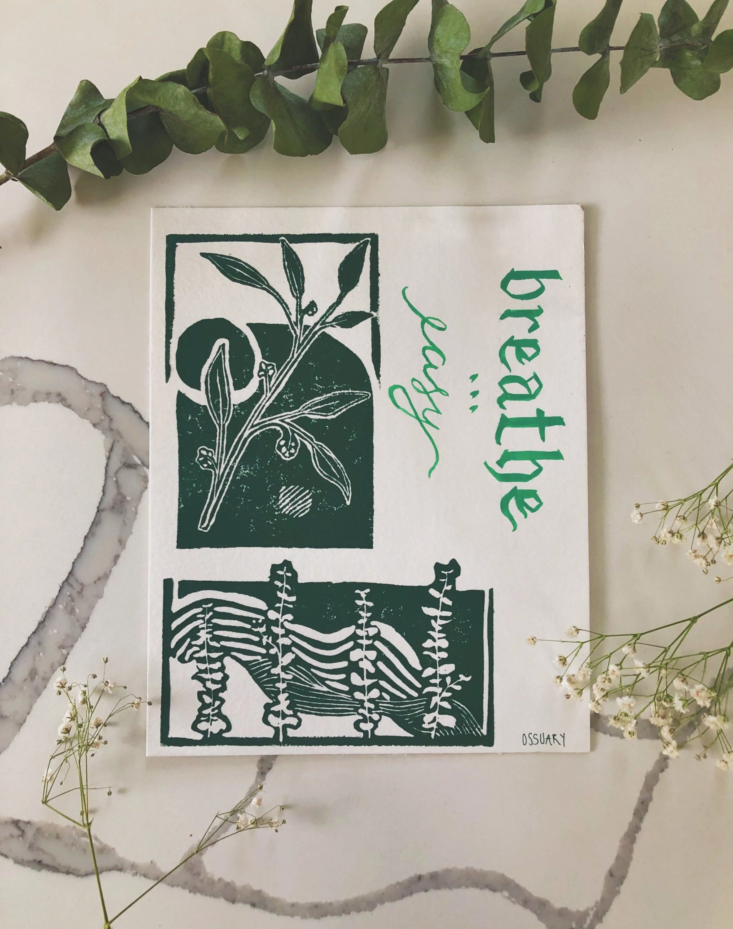 A card featuring botanical illustrations with the words "breathtaking beauty" written in green cursive and printed text. The card is surrounded by green leaves and small white flowers.