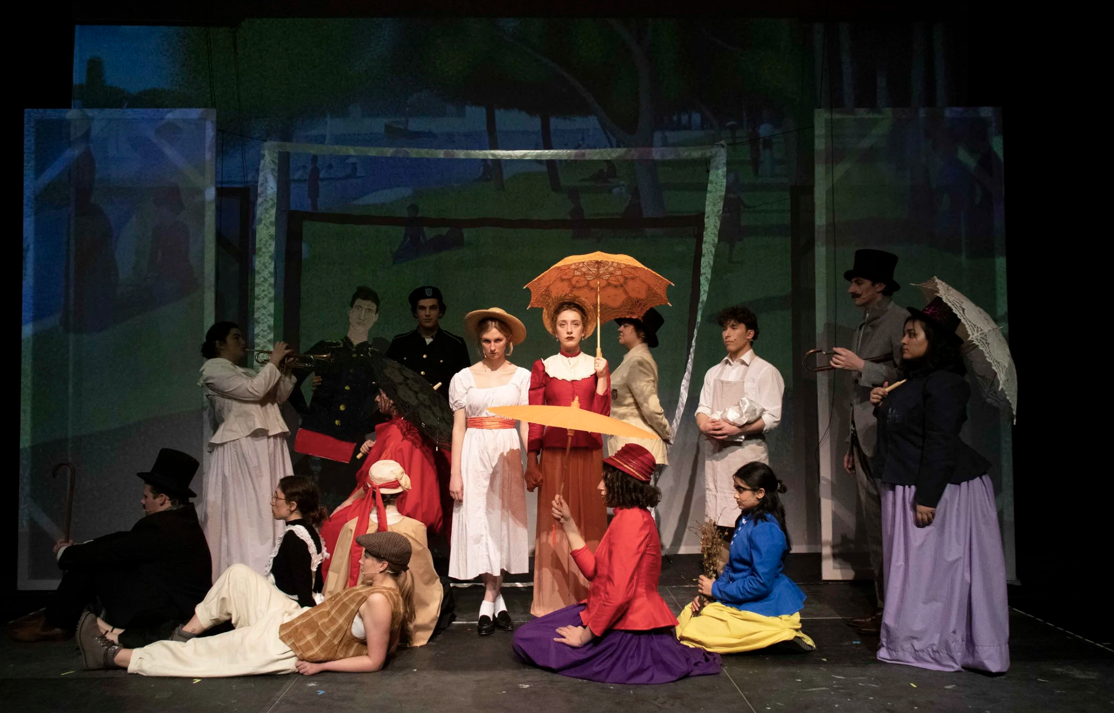Stage scene from a theatrical play featuring actors in vintage costumes, some holding umbrellas, with a painted backdrop of a park in the background.