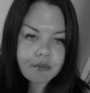 Close-up black and white photo of a woman with straight dark hair and a neutral expression.