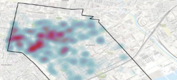 Heatmap over a city map showing red and blue data points within a district boundary.