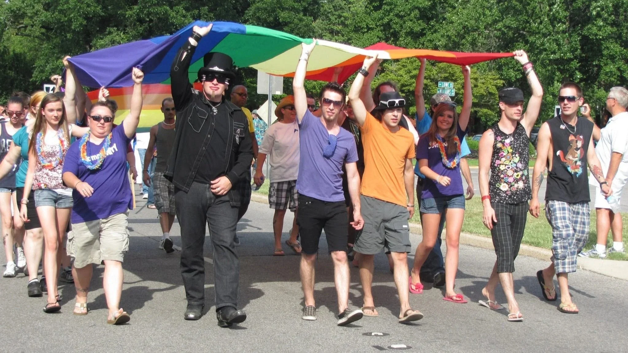 Rocket City Pride 2012 parade participants walking together while carrying a large rainbow Pride flag during a community event. Scot Wedgeworth from Bama Glama, MTV