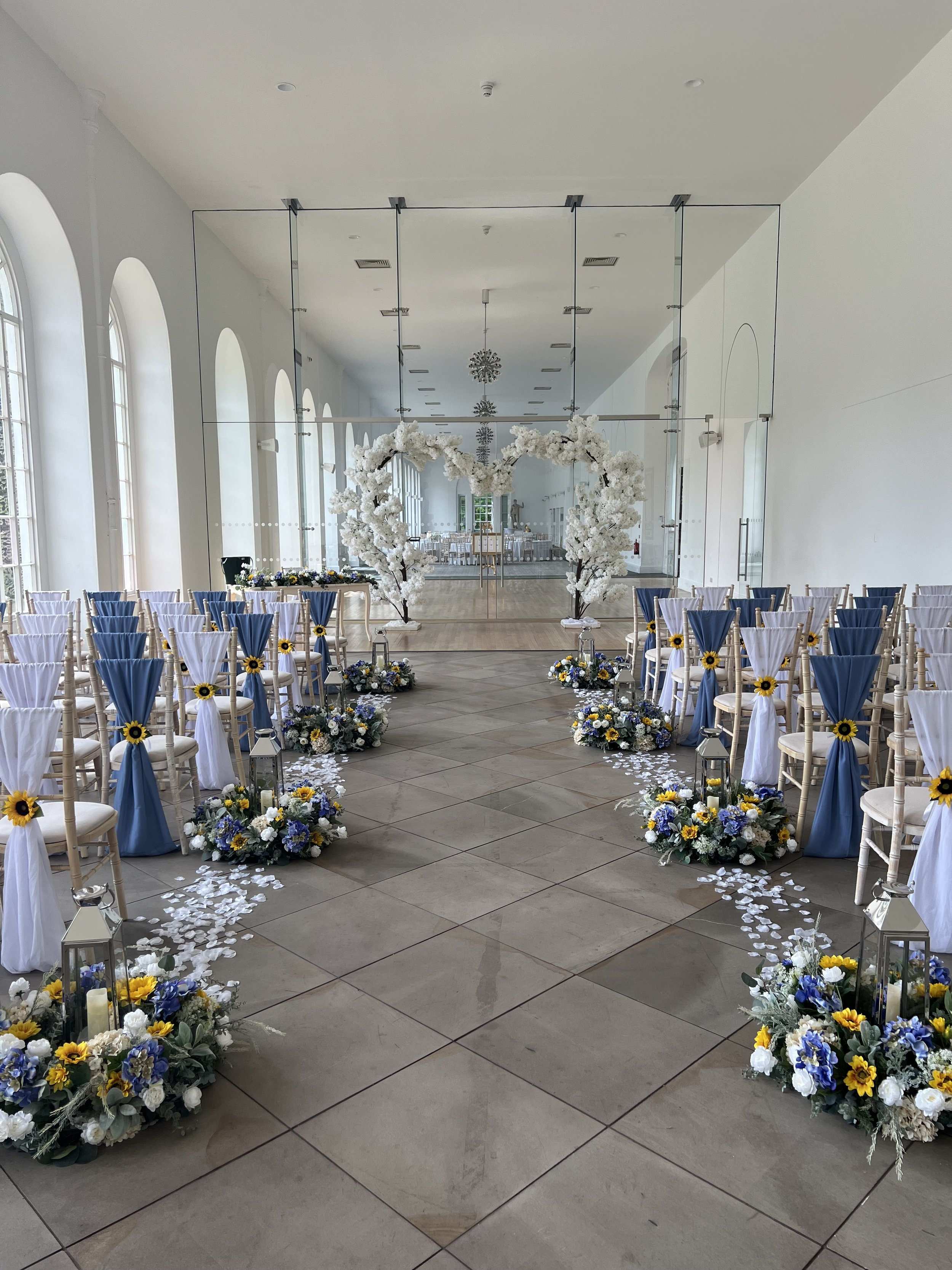 Indoor wedding ceremony set up with sunflowers at Margam Orangery, Margam Country Park, Neath Port Talbot, South Wales