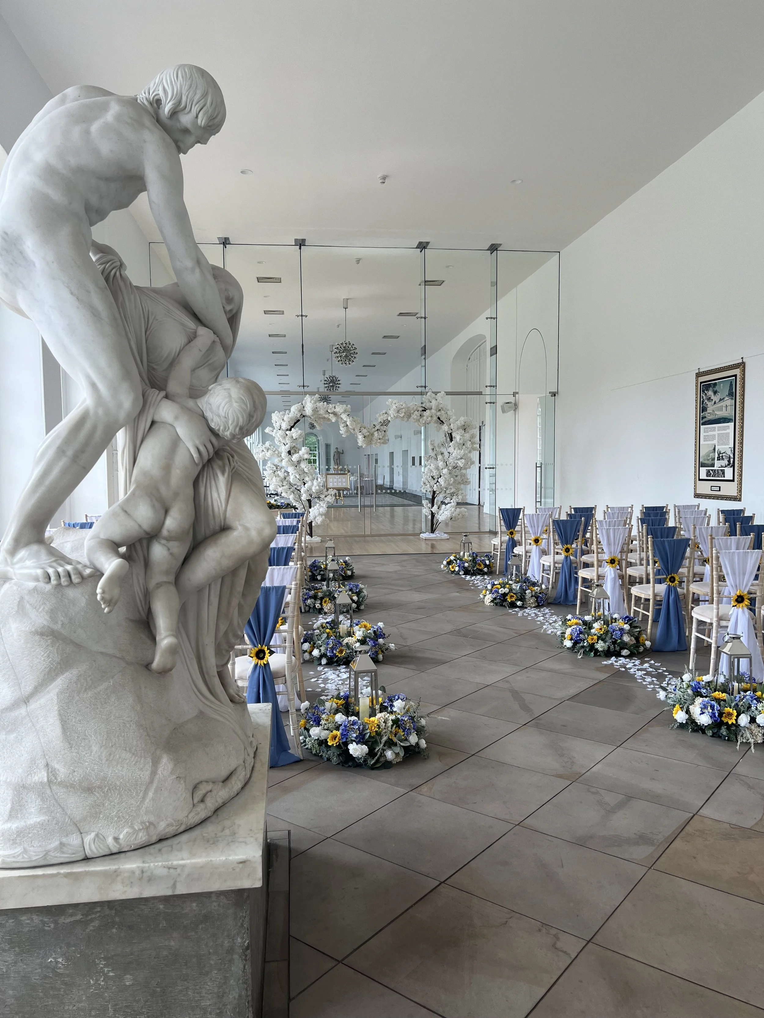 Indoor wedding ceremony set up with sunflowers at Margam Orangery, Margam Country Park, Neath Port Talbot, South Wales