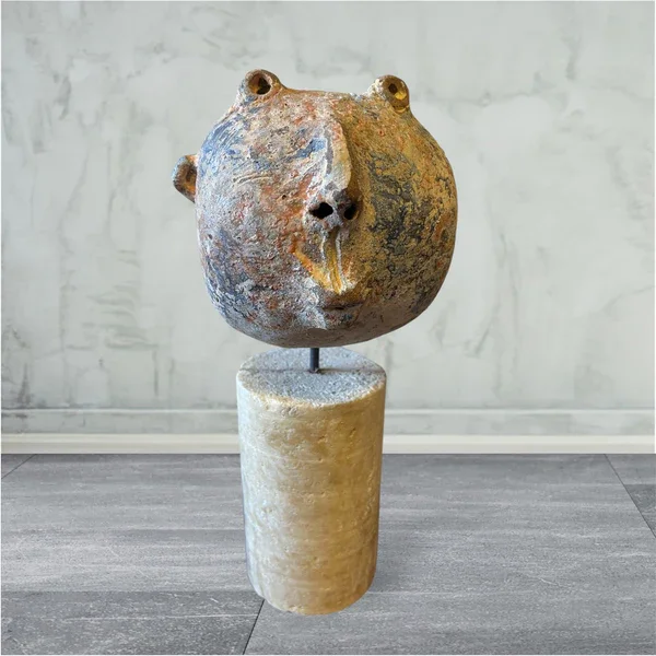 ceramic head on a stone pedestal.webp