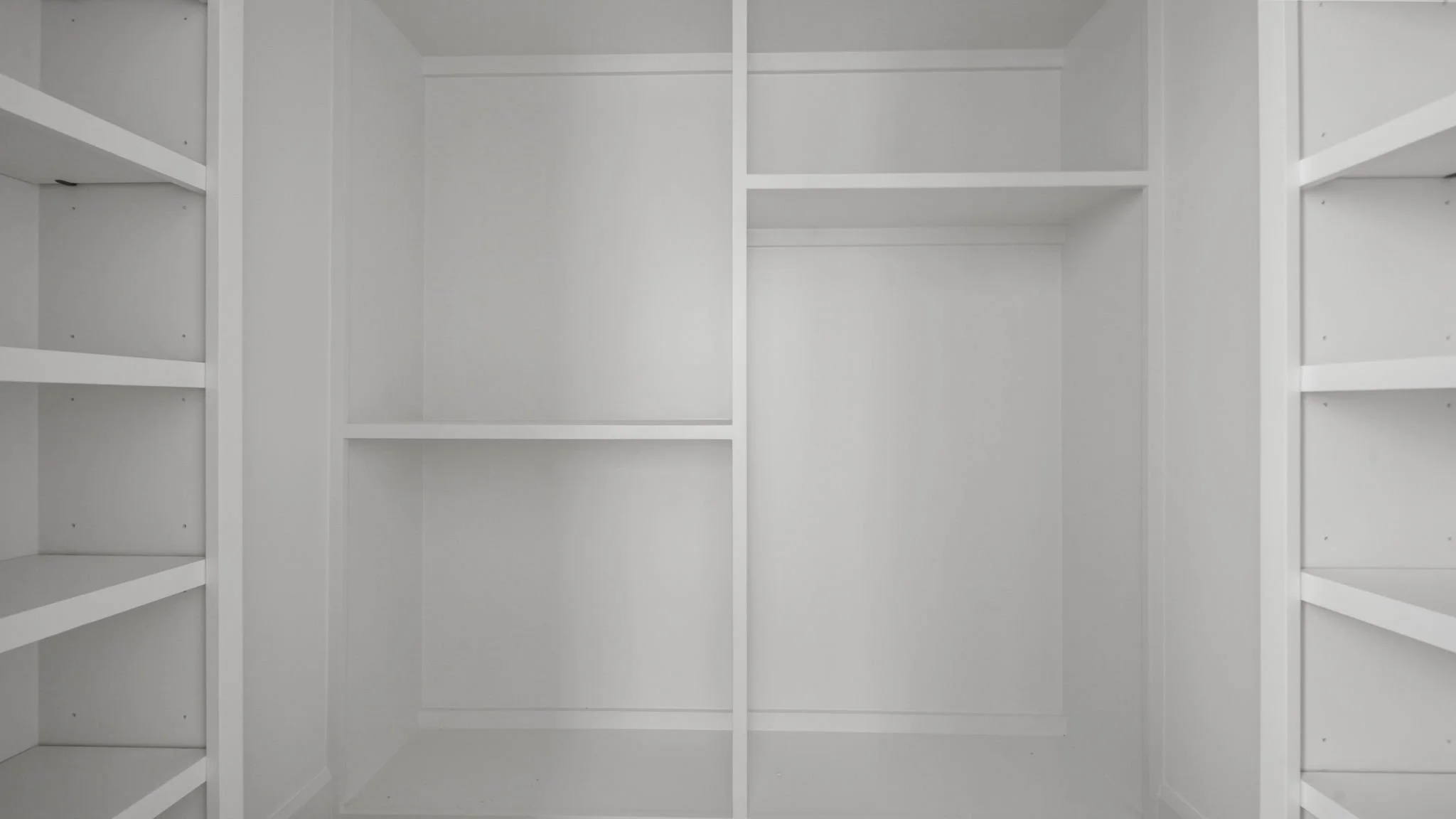 Empty white closet with multiple shelves.