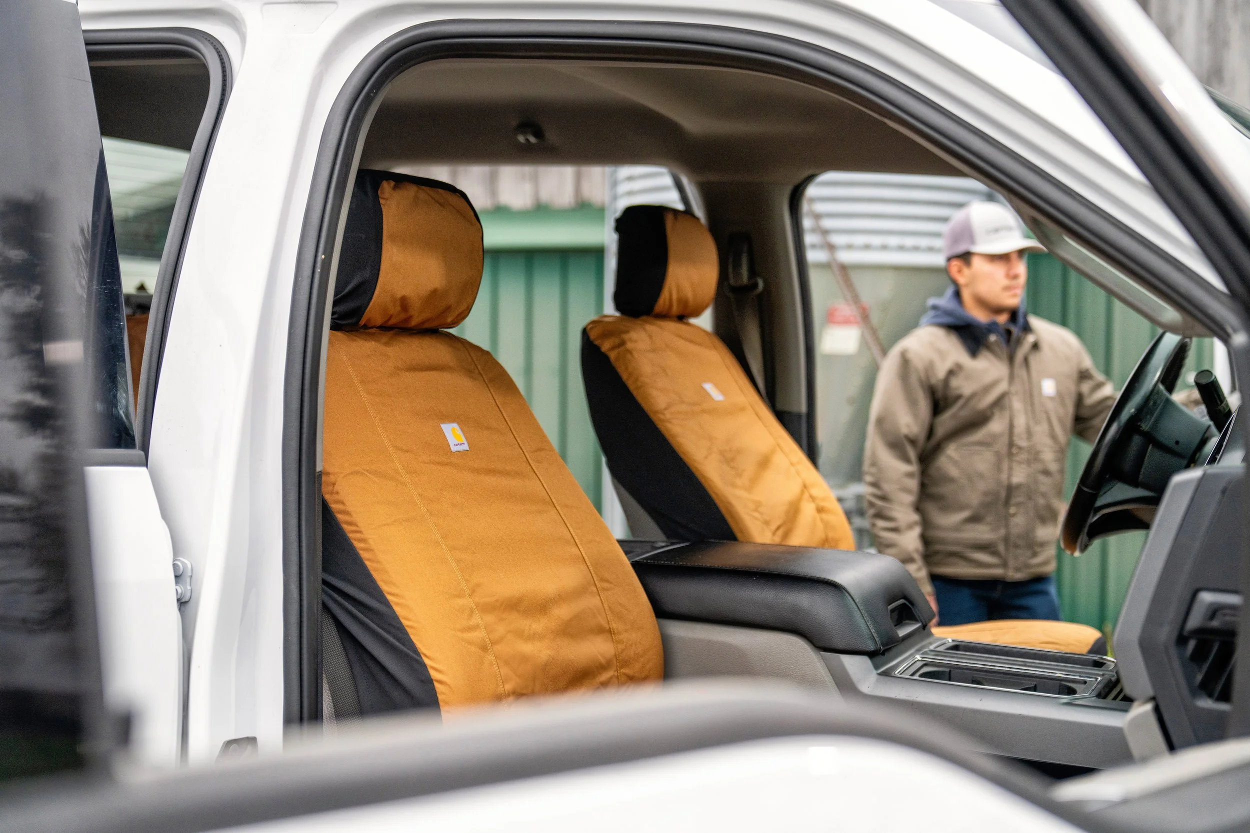 Person sitting in a Jeep with Hurley seat covers