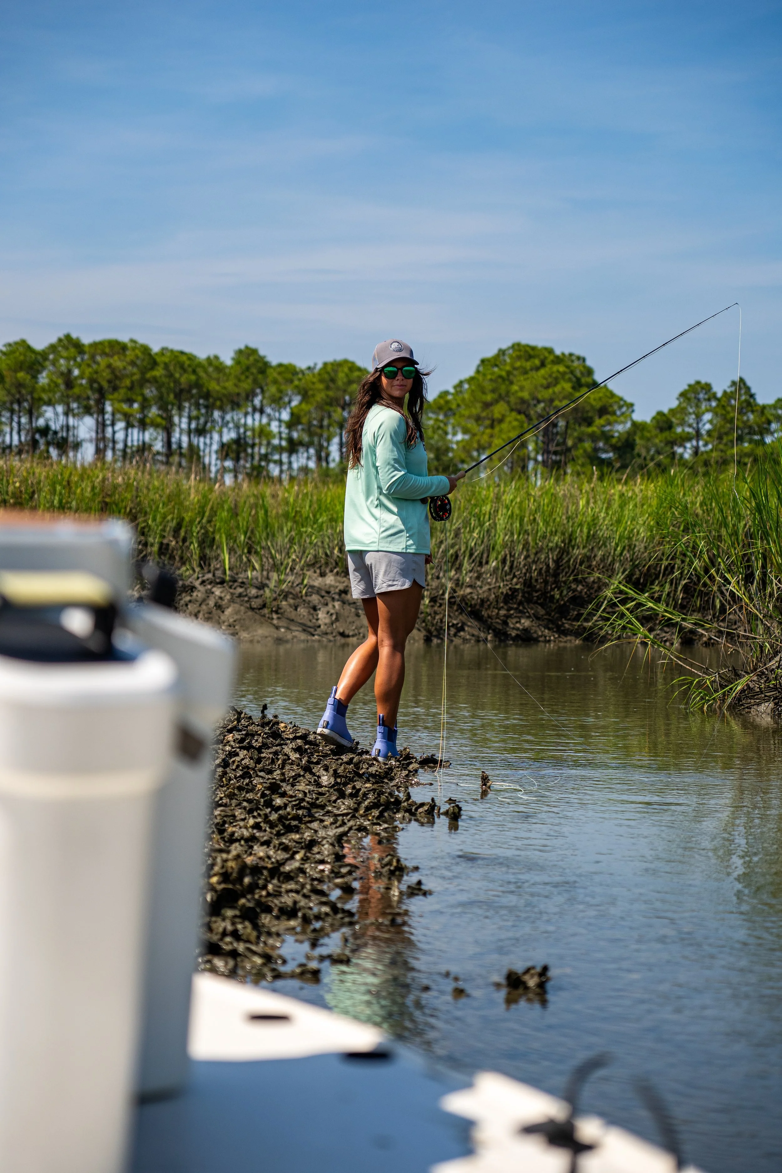 Woman wearing a Huk long sleeve shirt fishing