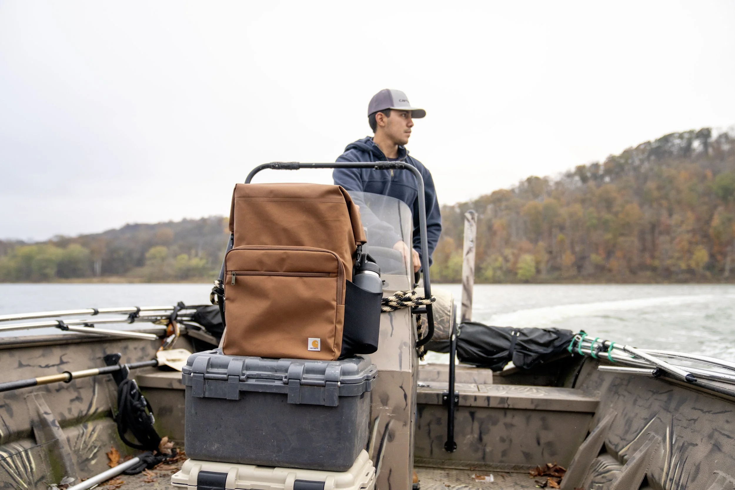 Man on a fishing boat with a Carhartt bag