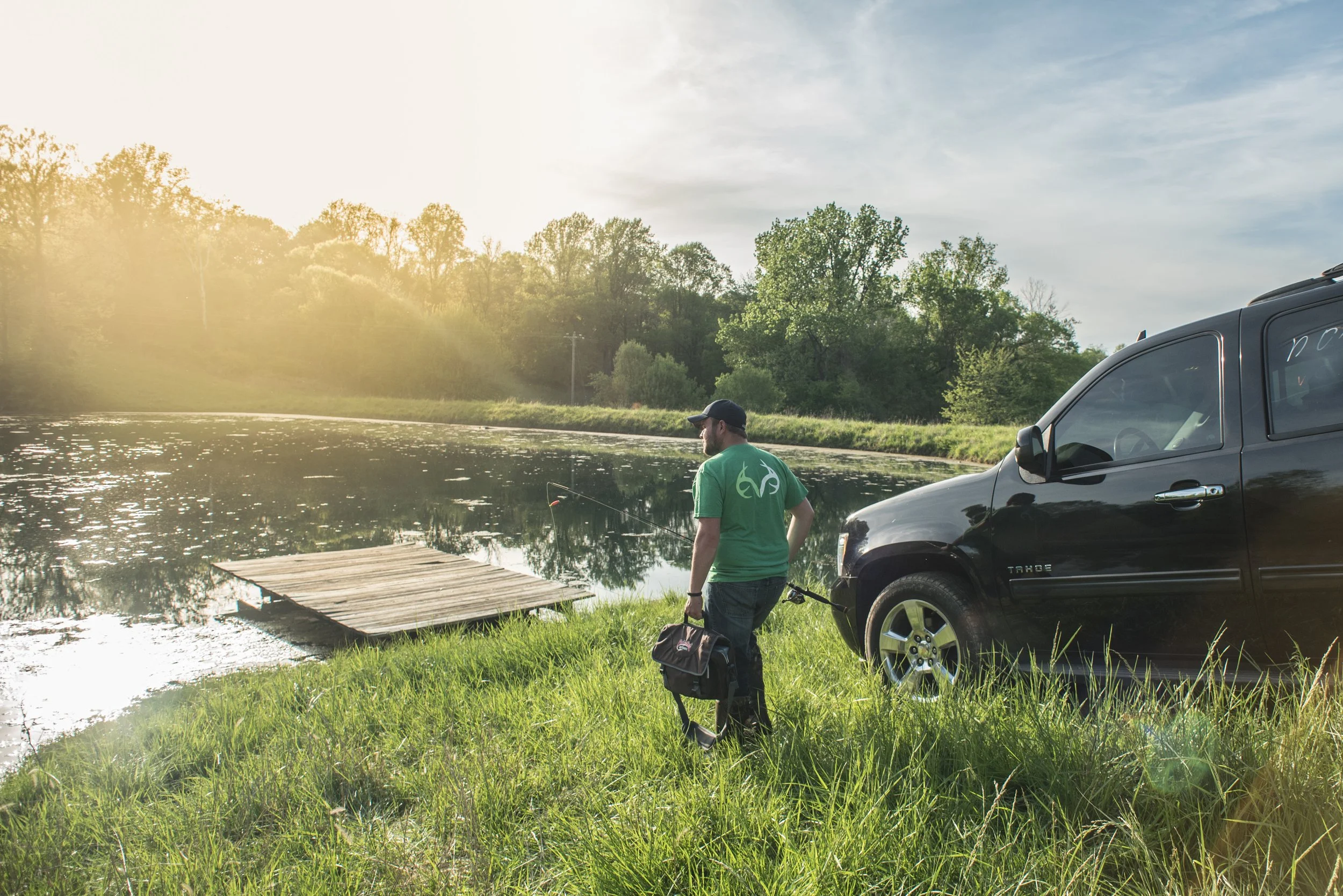 Man wearing Realtree shirt walking towards a river