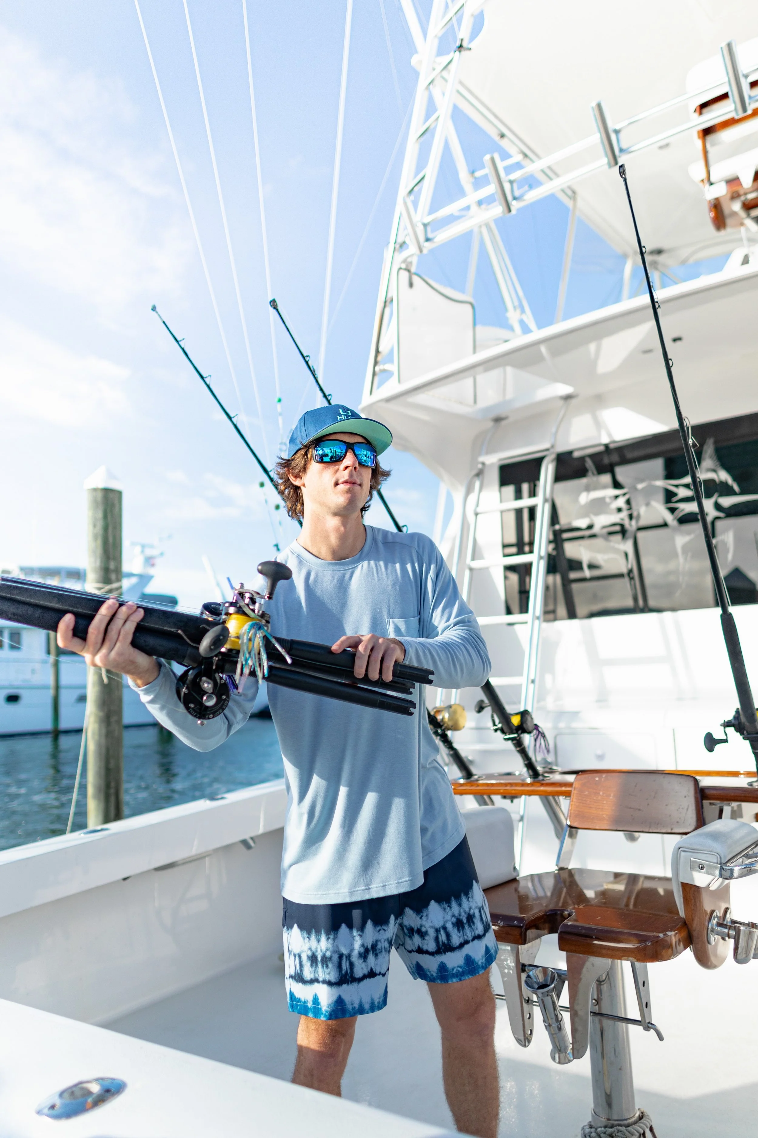 Man on a fishing boat wearing Huk sunglasses and shirt