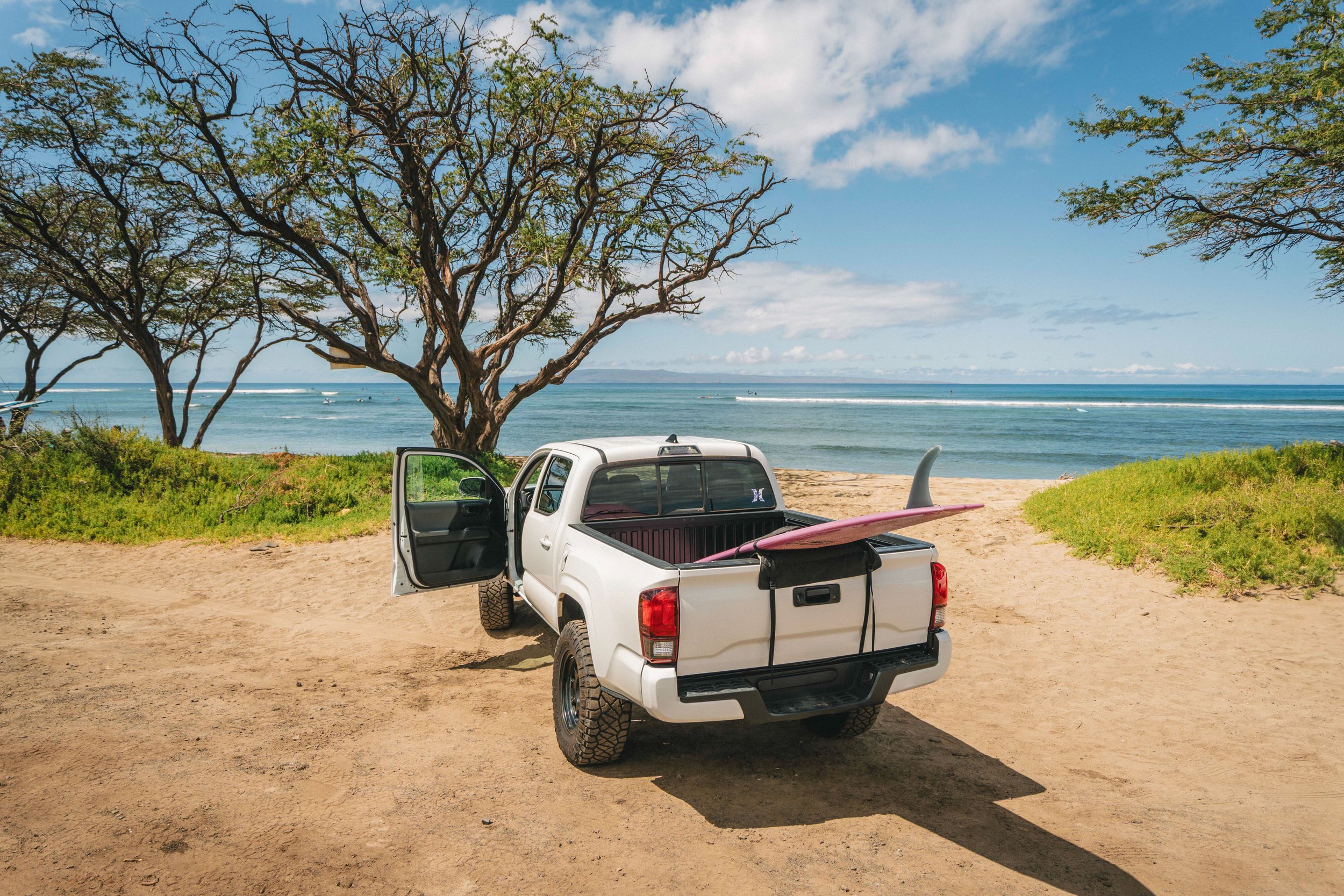Truck with a surfboard in the bed, with Hurley truck bed protective cover