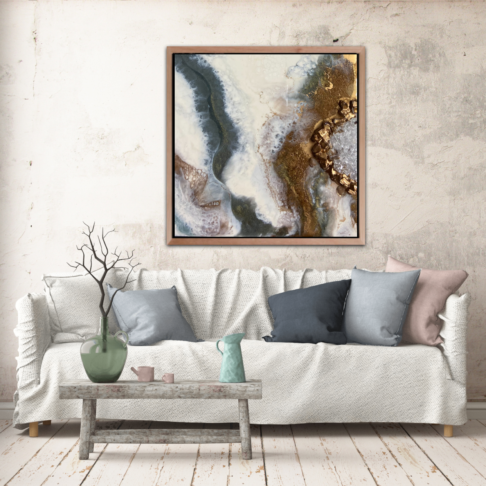 Living room with a white textured sofa, gray and blush pillows, a rustic wooden coffee table with a green vase, pink cups, and a pale blue pitcher, abstract Tatyana Y. Kravchenko's wall art, and a decorative branch in a green vase.