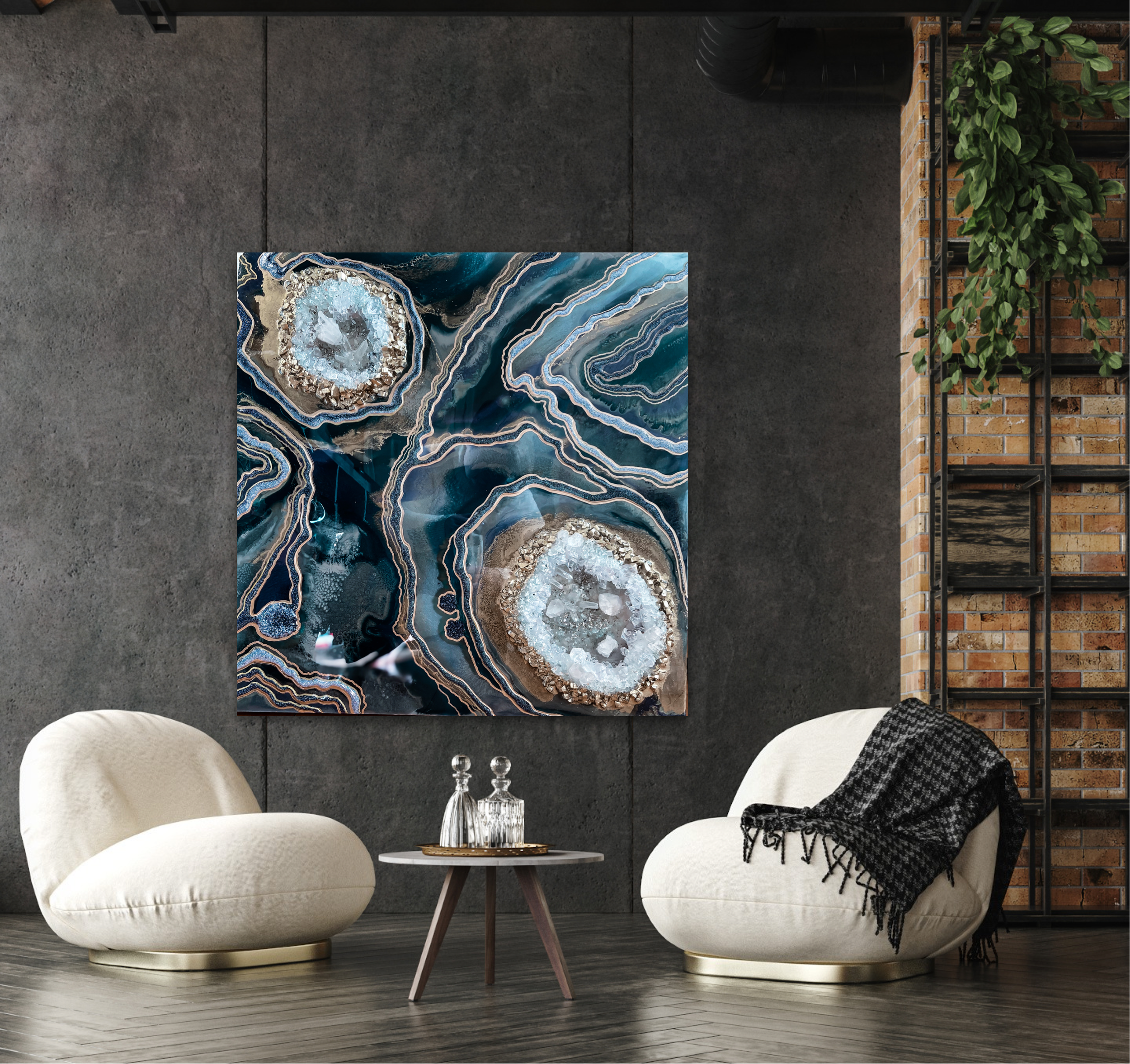 Modern living room with abstract Tatyana Y. Kravchenko's geode artwork on a dark wall, two white curved armchairs, a small round wooden table with glass decanters, and a brick wall with a black metal shelving unit holding a green plant.