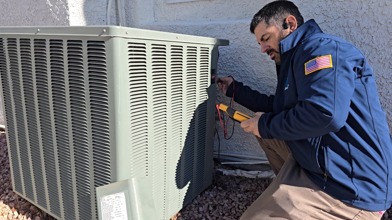 A technician is inspecting an outdoor HVAC unit with testing equipment.