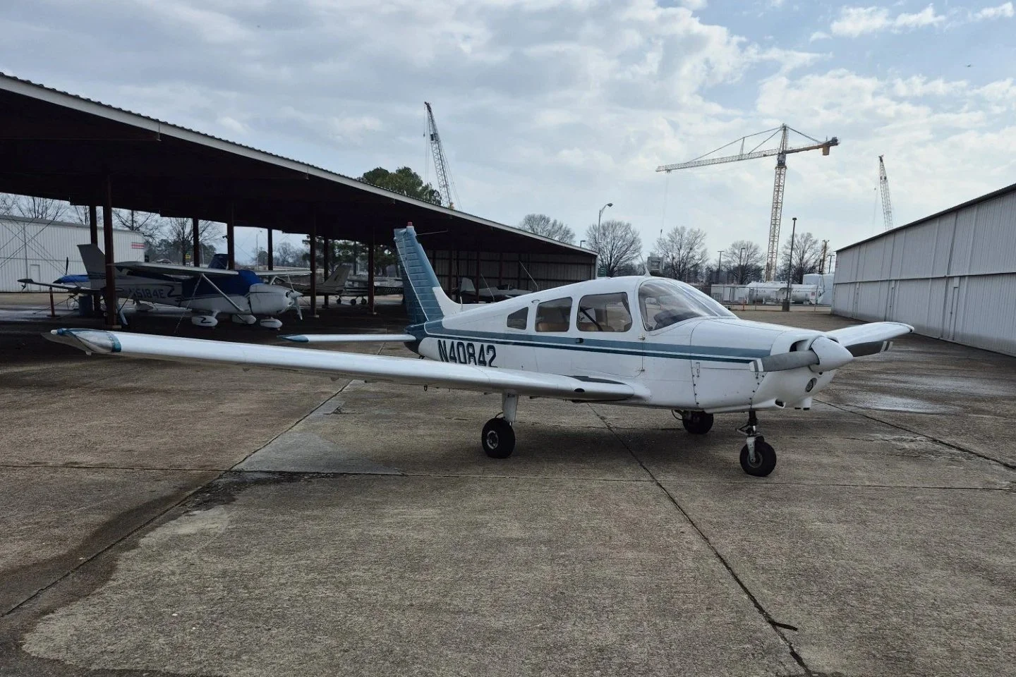 A white and green Piper PA-28-151 Warrior II airplane.