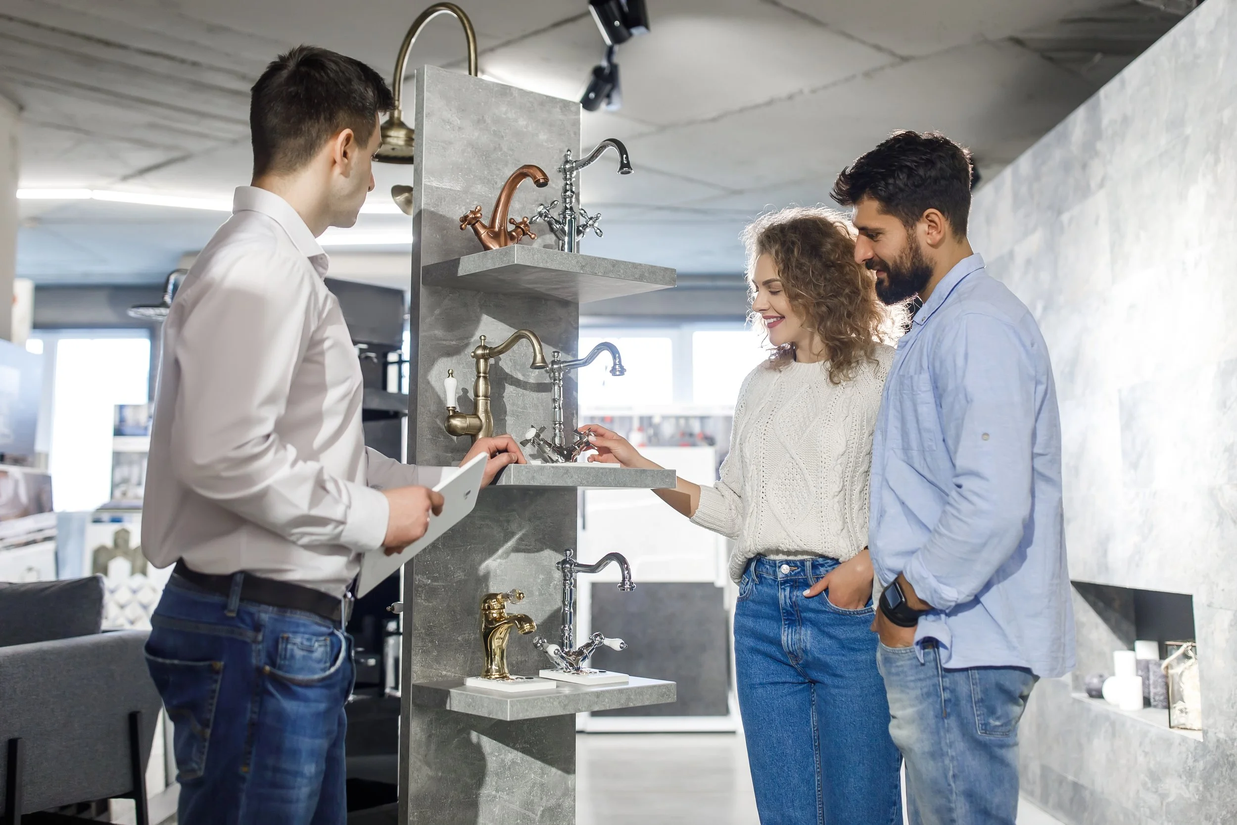 Homeowners selecting plumbing fixtures with remodeling professional during design-build renovation planning
