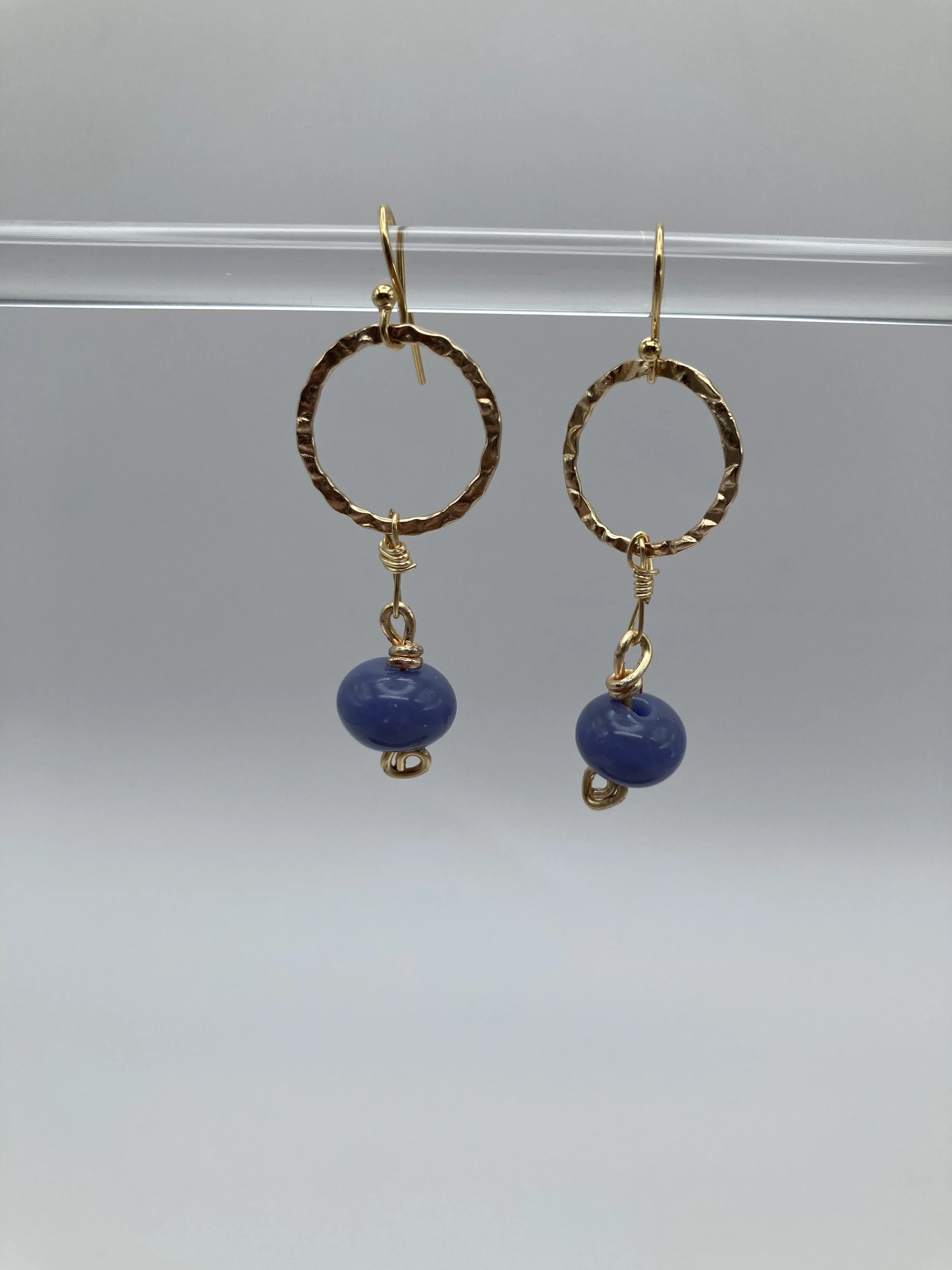earrings with blue glass beads hanging from gold circles