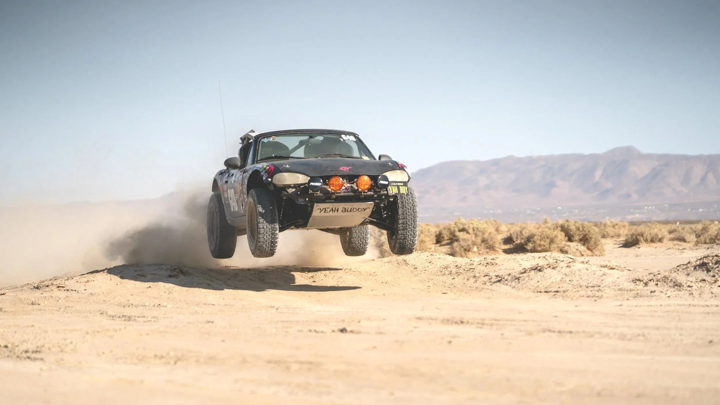 Buddy the Off Road Miata taking flight out in Johnson Valley, CA. Photo by Dusty Summit.