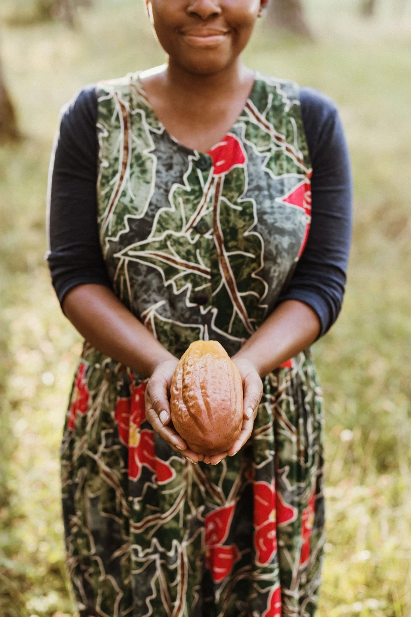 Mujer sosteniendo un cacao en un campo