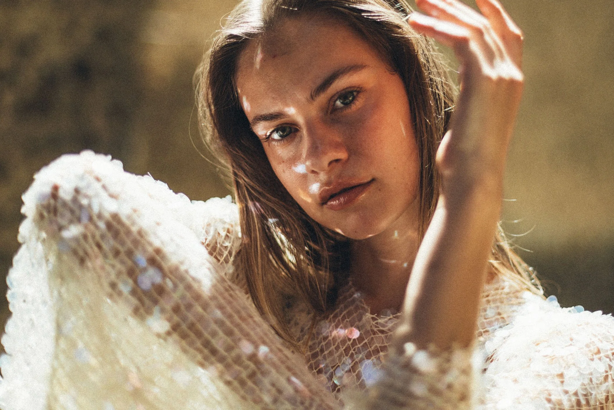 Retrato cercano de una mujer joven con cabello rubio y ojos claros, luciendo una expresión serena, en un entorno con luz natural y fondo difuso.