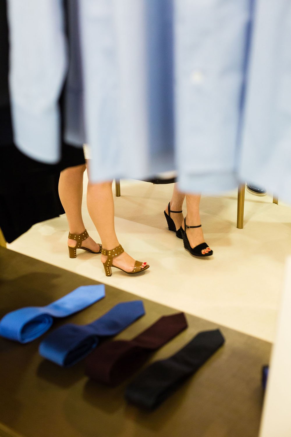 Zapatos de mujer en una tienda, con una mesa que muestra corbatas en primer plano.