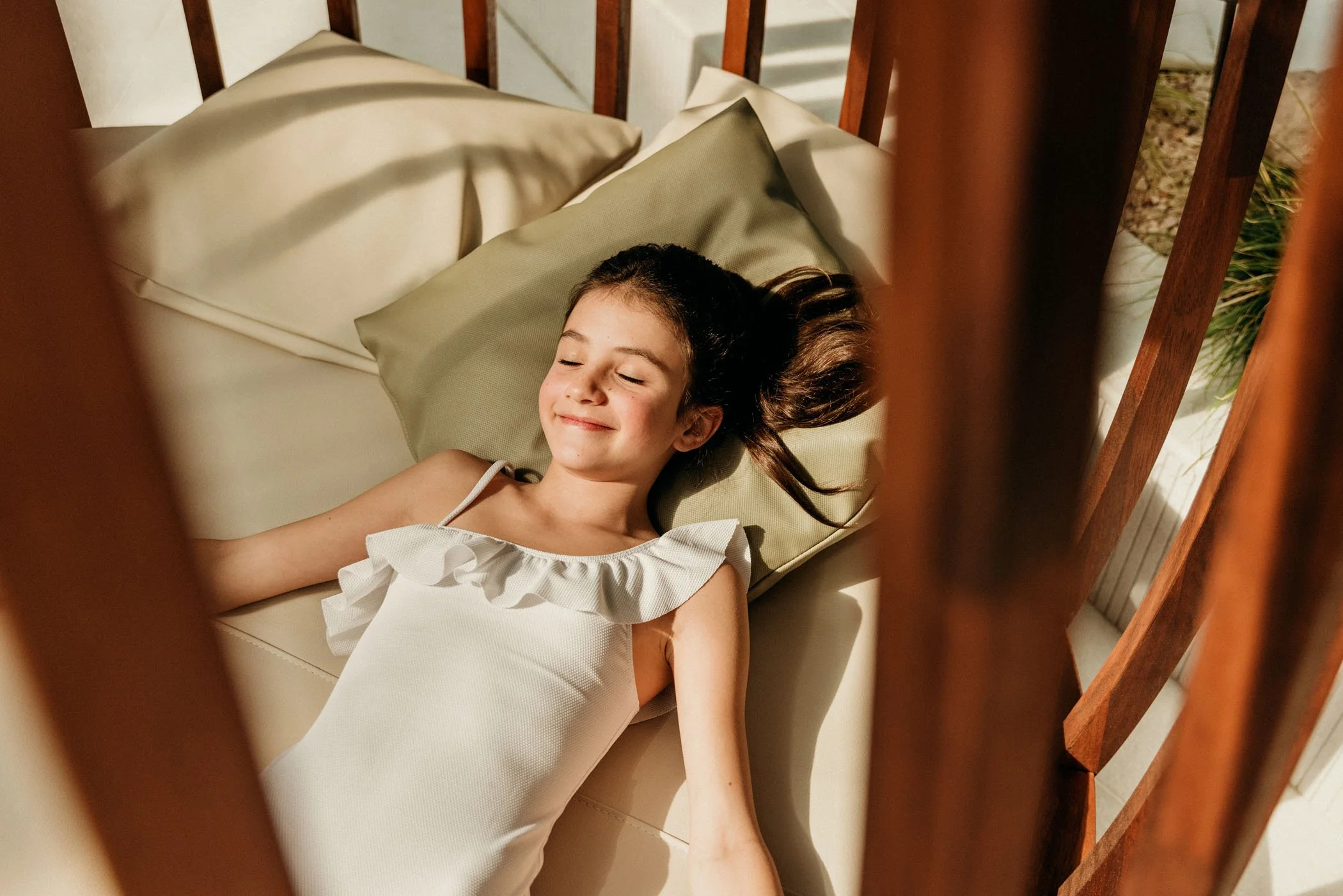 Niña dormir en una cama con almohadas, vista desde arriba.