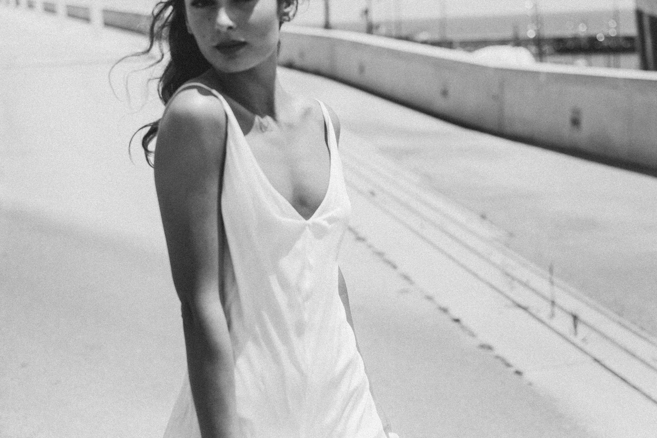 Mujer con vestido blanco en un entorno urbano al aire libre en blanco y negro