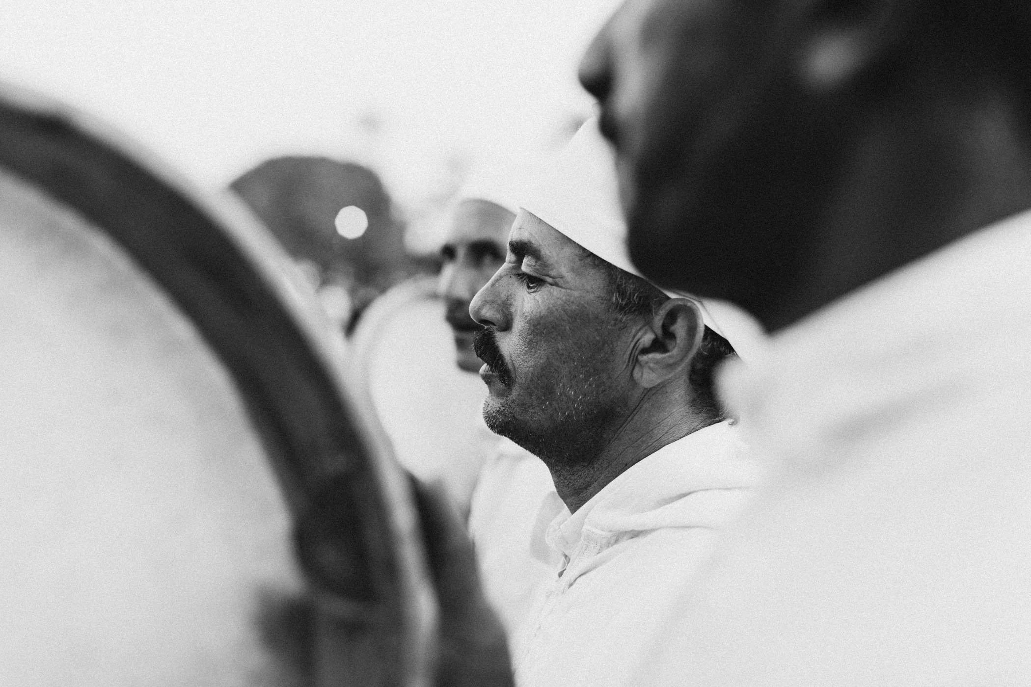Hombres en uniforme y gorro, en perfil, en una fila.