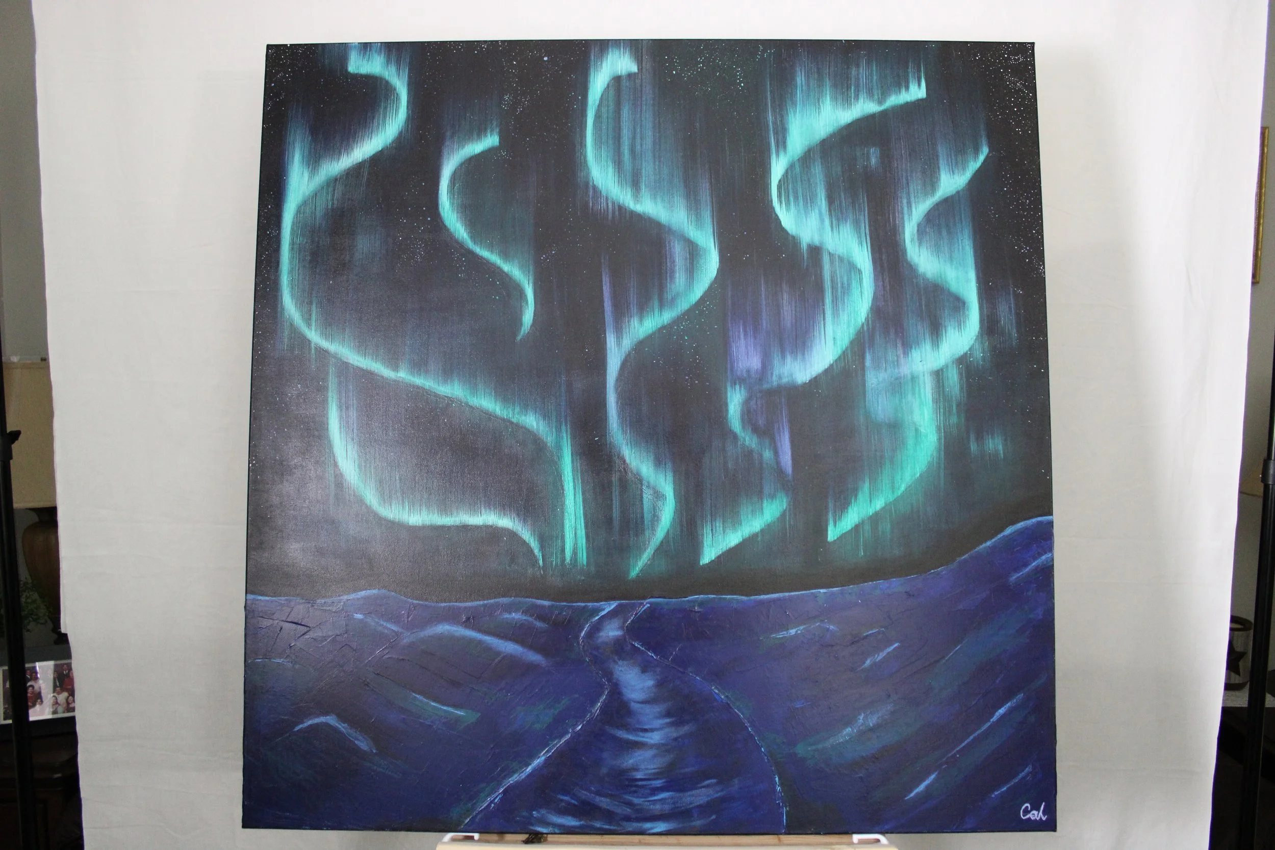 Painting of the northern lights over a dark landscape with a winding river, signed by Cal.