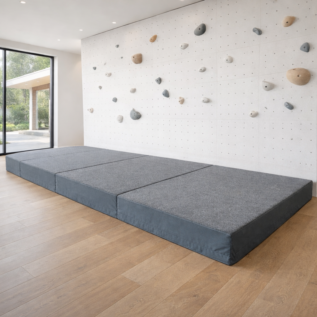 Dark gray carpet-topped bouldering wall landing mats in a clean, modern house with a white panelized climbing wall. (Copy)