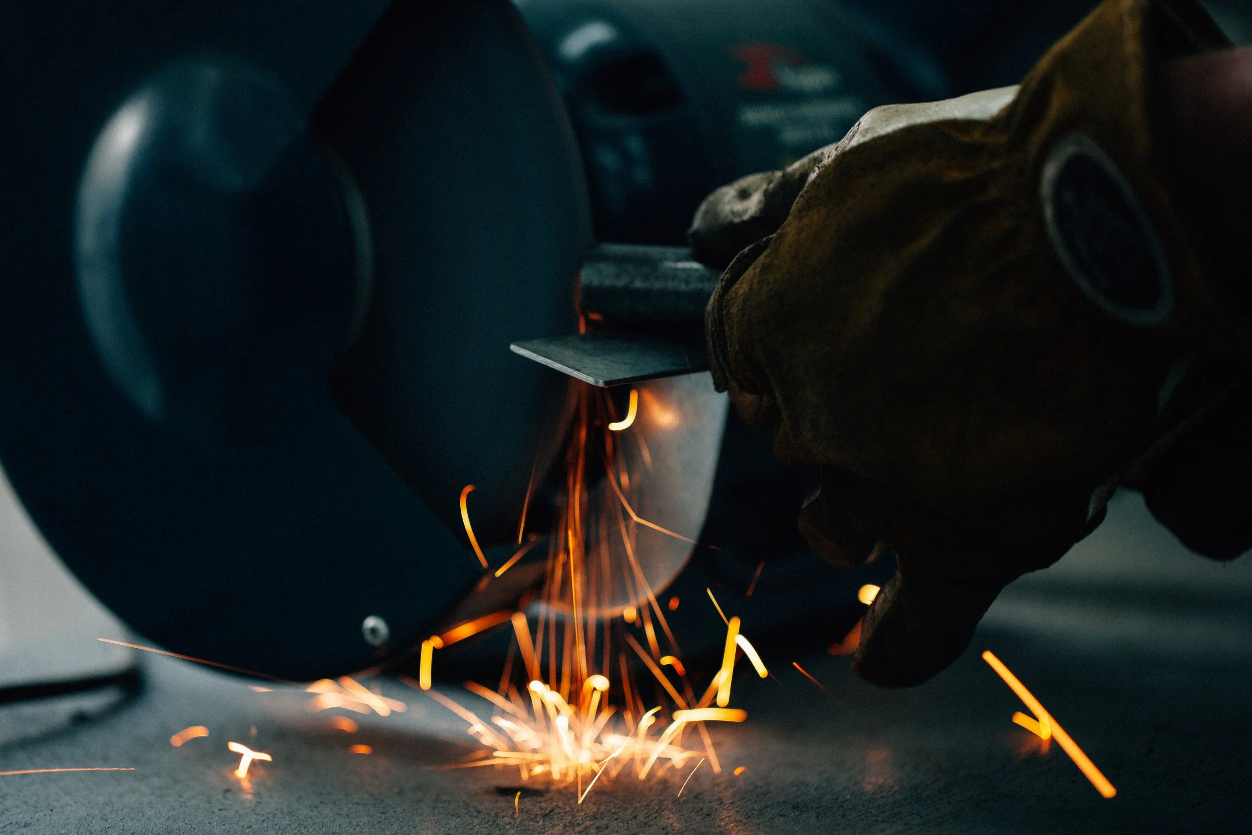 Close-up of a person welding metal with sparks flying from the welding process.