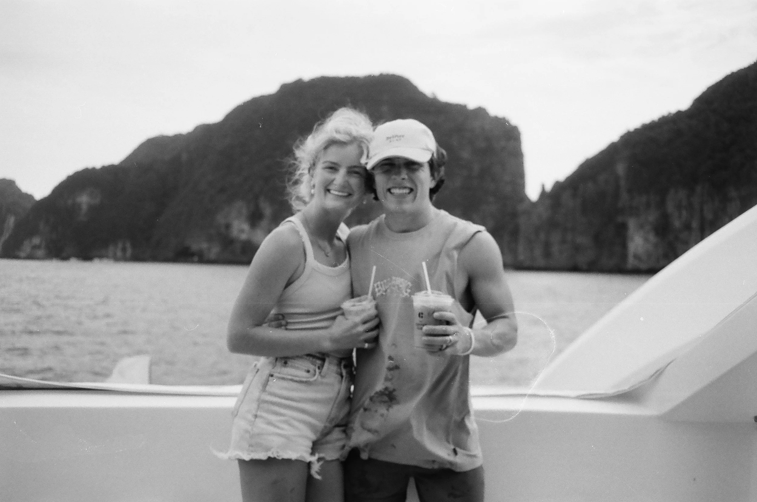 The husband and wife (Sam and Alexandra Swansen) owners of Twin Fin Coffee, in Aguadilla, PR, standing on a boat drinking iced coffee.