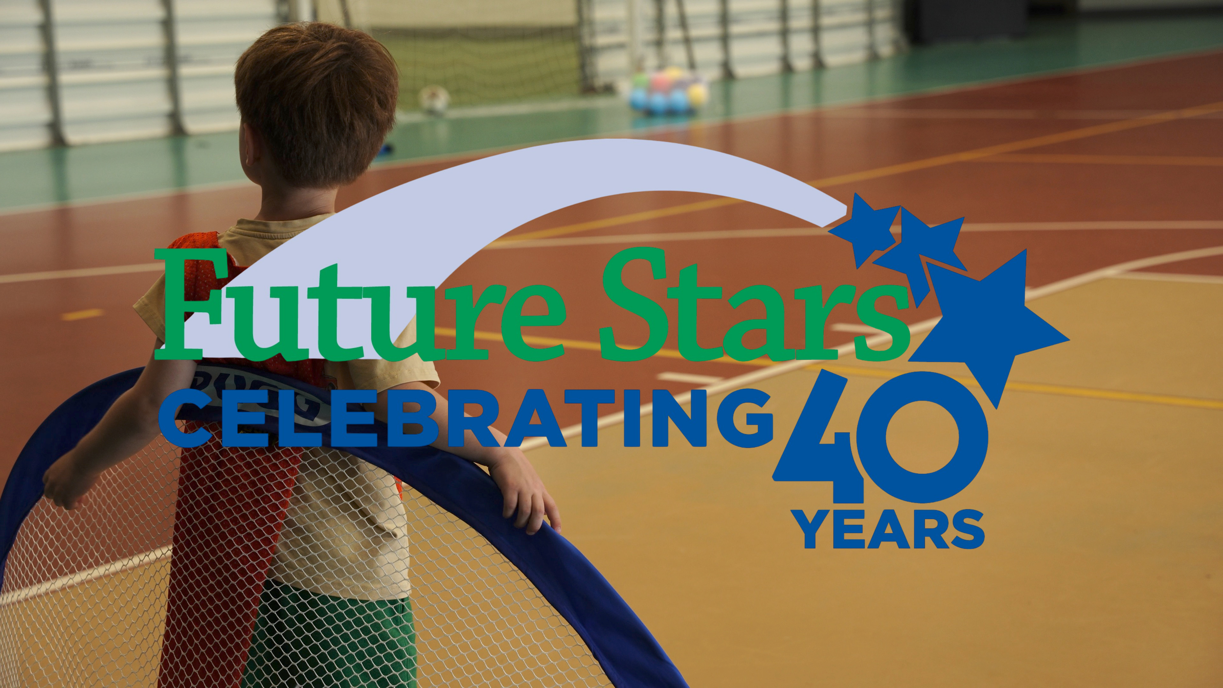 A young boy with red hair standing behind a net on an indoor sports court, with a colorful cluster of balls in the background and a graphic overlay celebrating 40 years of future stars.