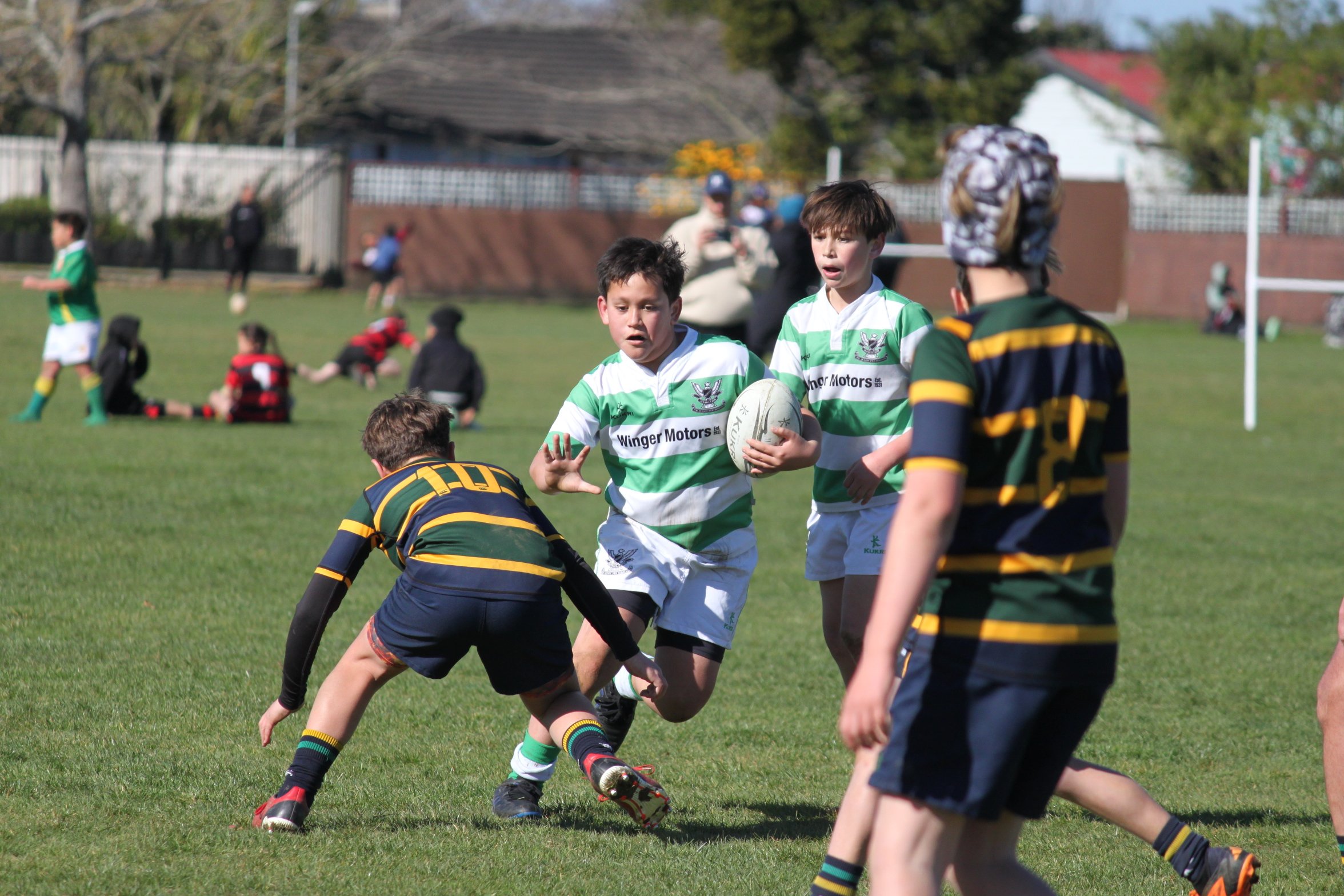 Waikato - Young boy holding rugby ball in tackle