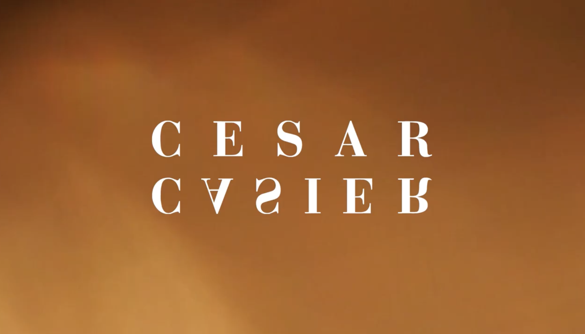 The image shows the name 'CESAR CASIER' written twice in white text, with one of the texts upside down, on a gradient brown background.