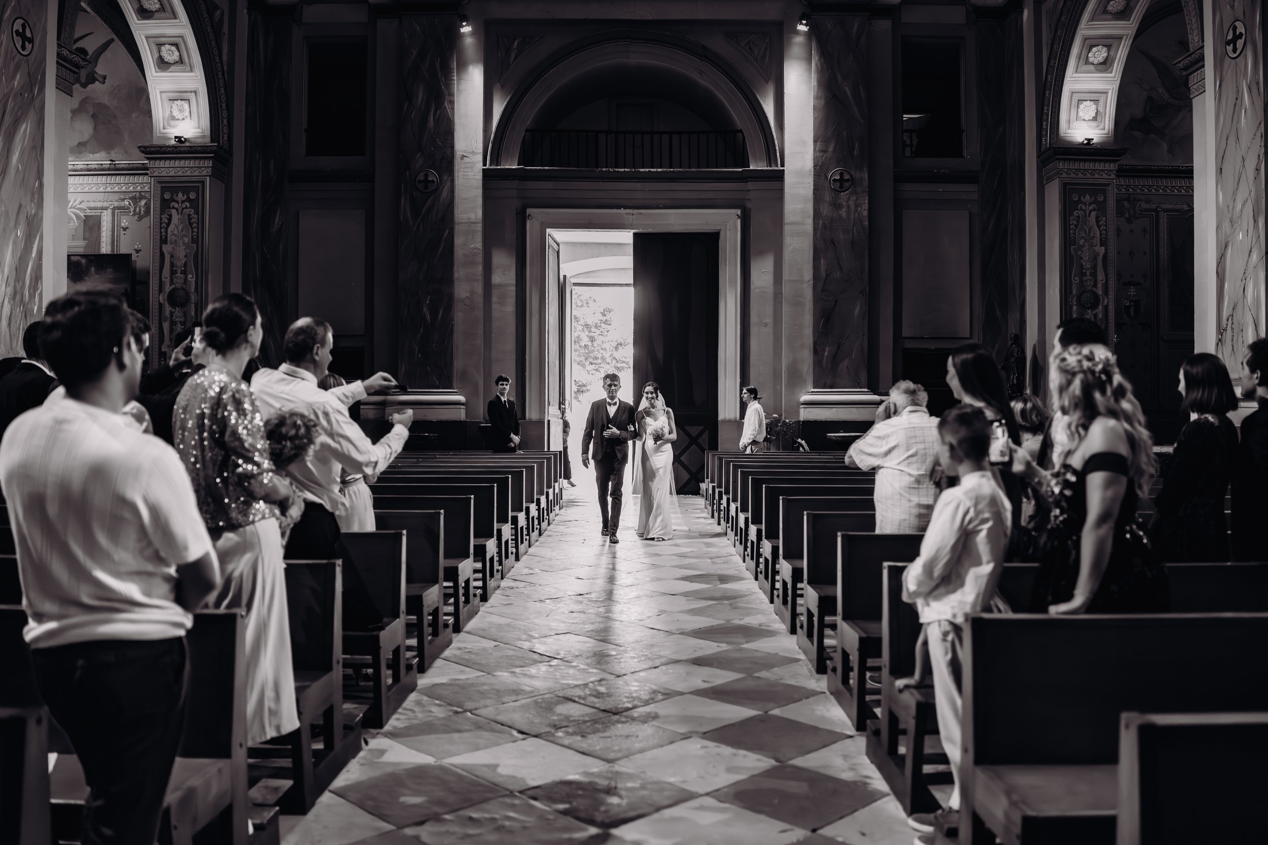 Mariage dans l'église de Seysse, près de Toulouse, en Occitanie, et on voit la mariée remonter l'allée au bras de son père. 