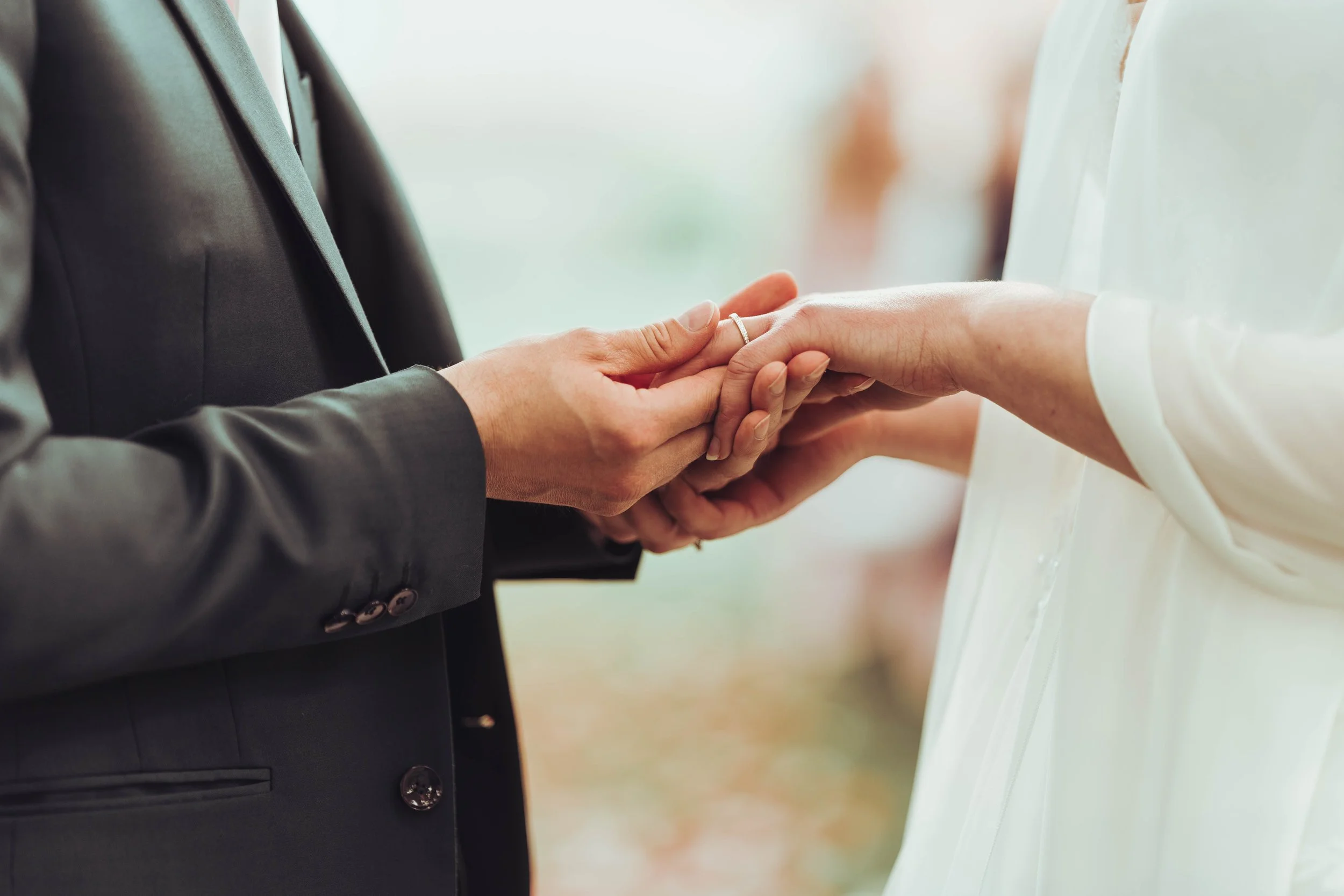 Un couple échangeant leurs anneaux de mariage lors d'une cérémonie nuptiale au château de Puydaniel. 