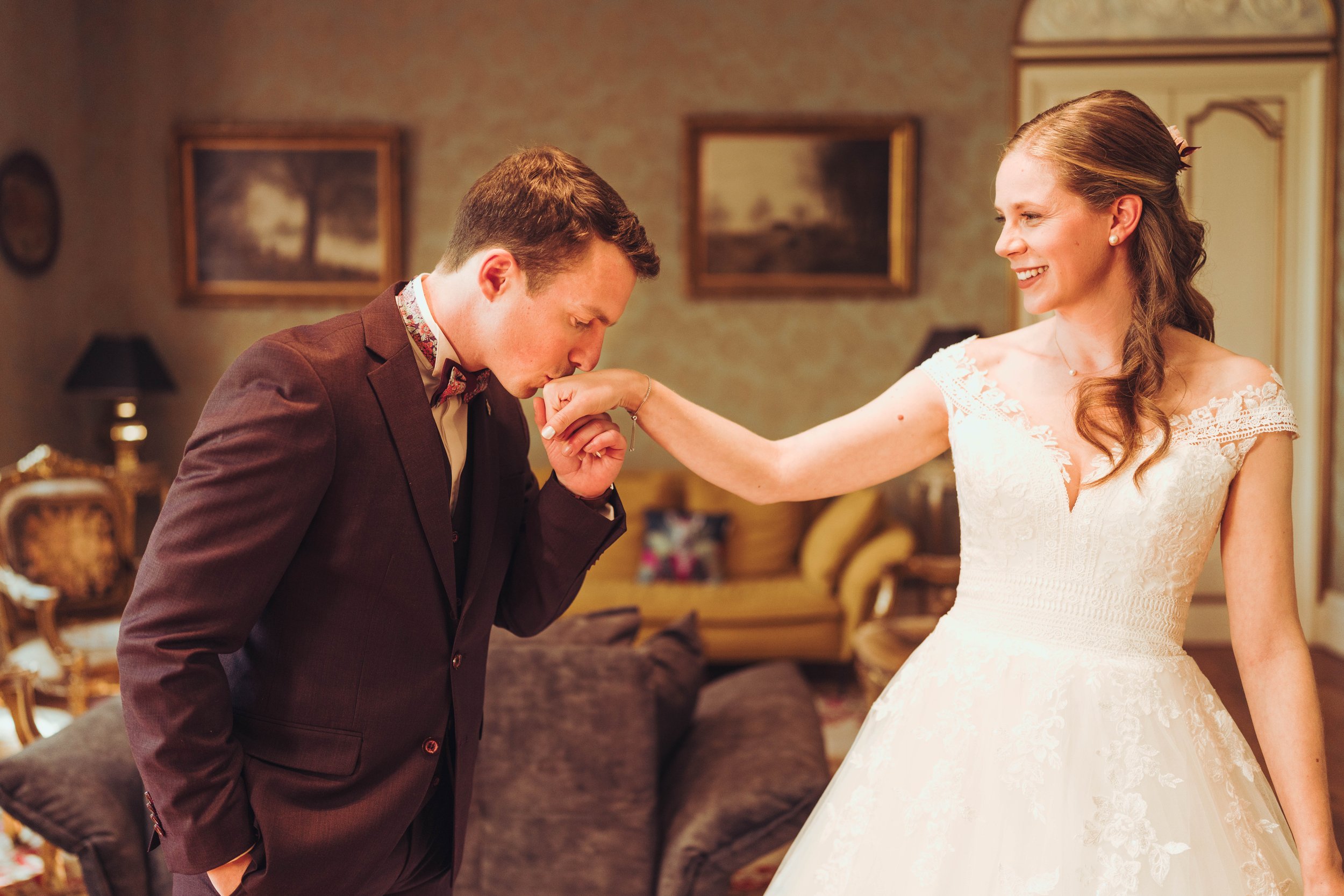 Le marié embrasse la main de la mariée dans le salon du manoir du Thouron près de Toulouse, en Occitanie. 