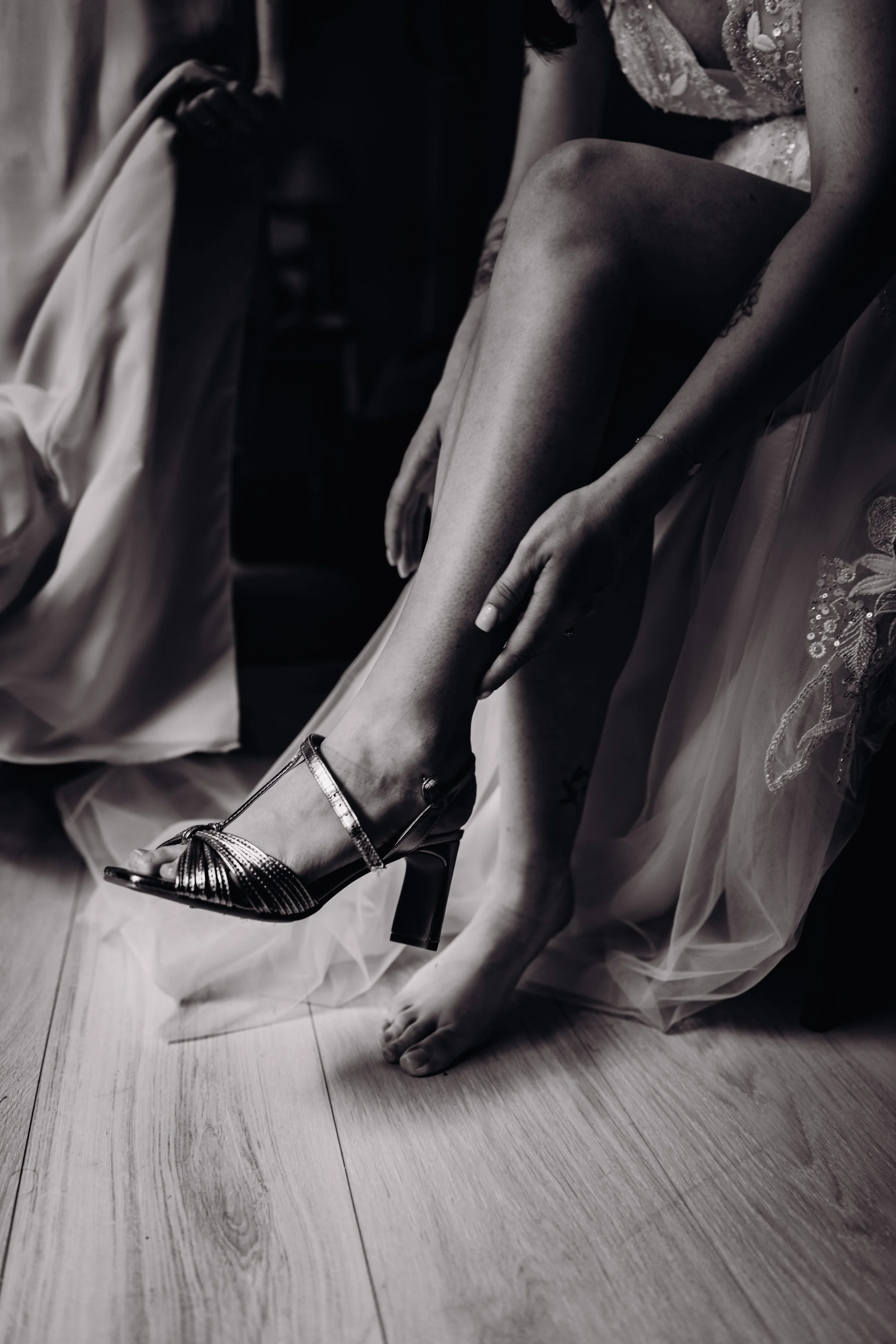 Une femme ajuste sa chaussure à talons hauts lors de ce qui semble être une préparation de mariage au domaine de Lalanne près de Toulouse, en Occitanie. 